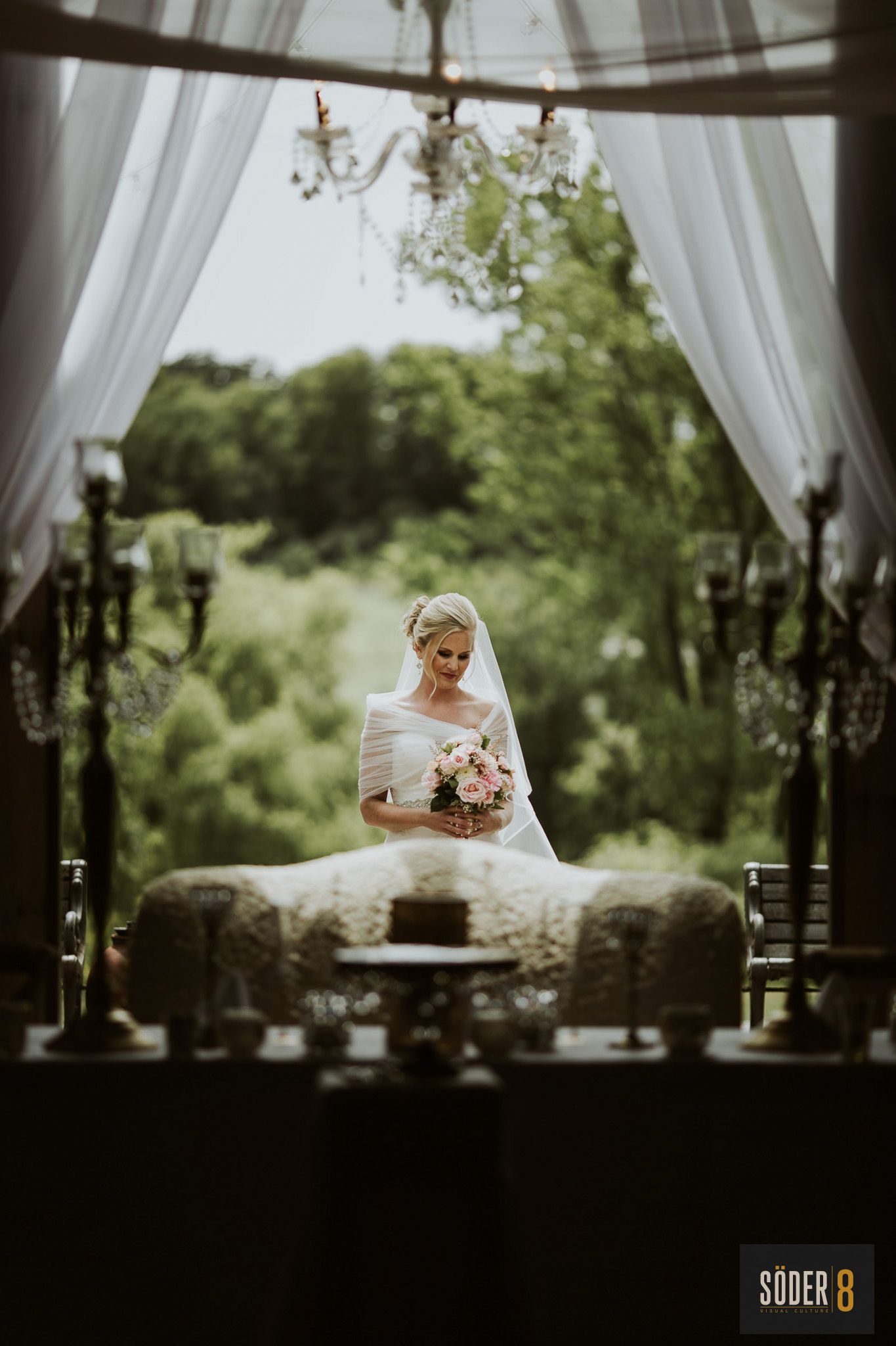 bride holding flowers in barn door light