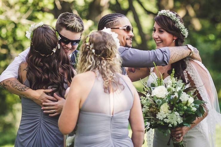 same sex wedding couple hugging friends after ceremony in clear lake iowa