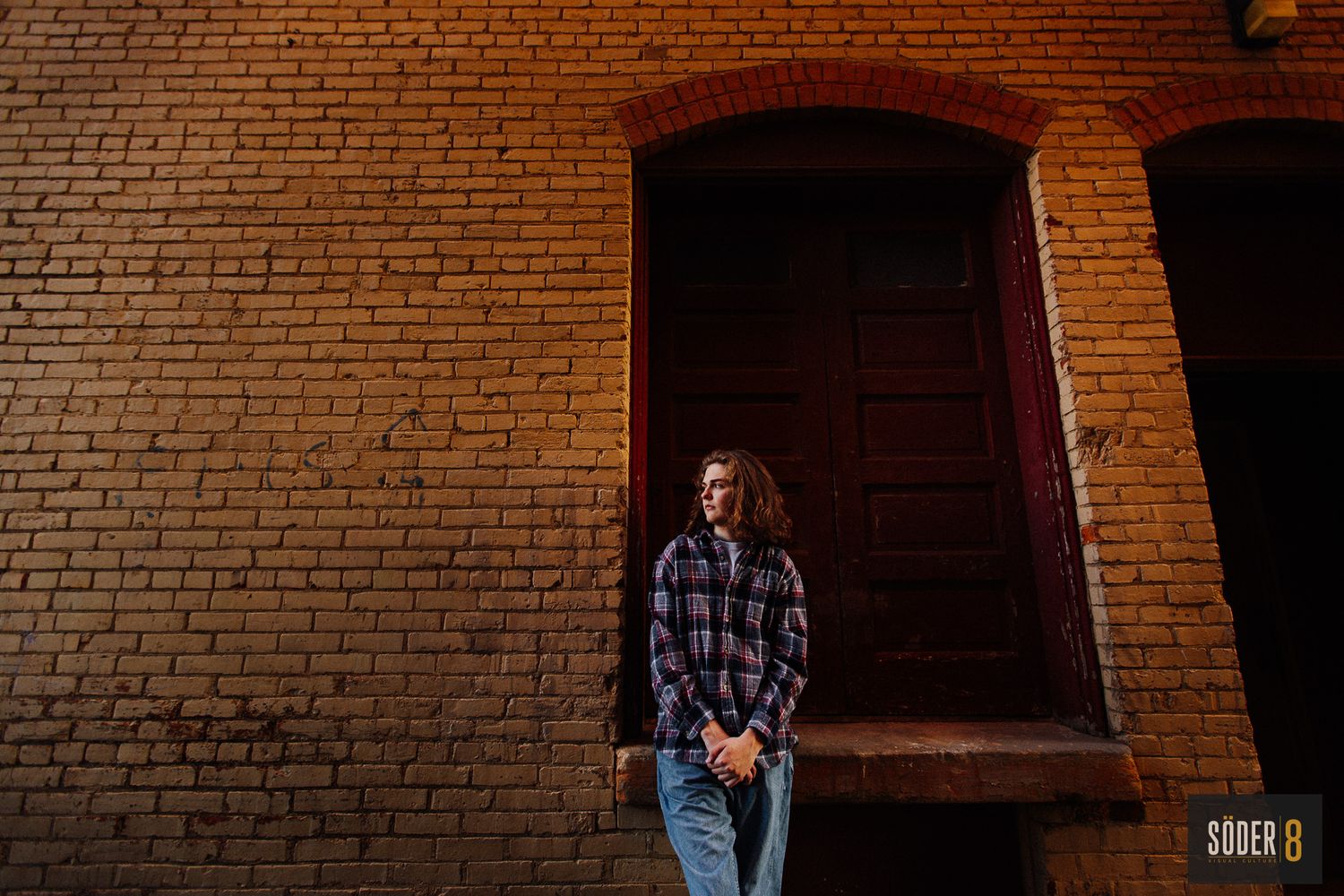 high school senior standing in alleyway next to brick wall in mason city, iowa - soder8