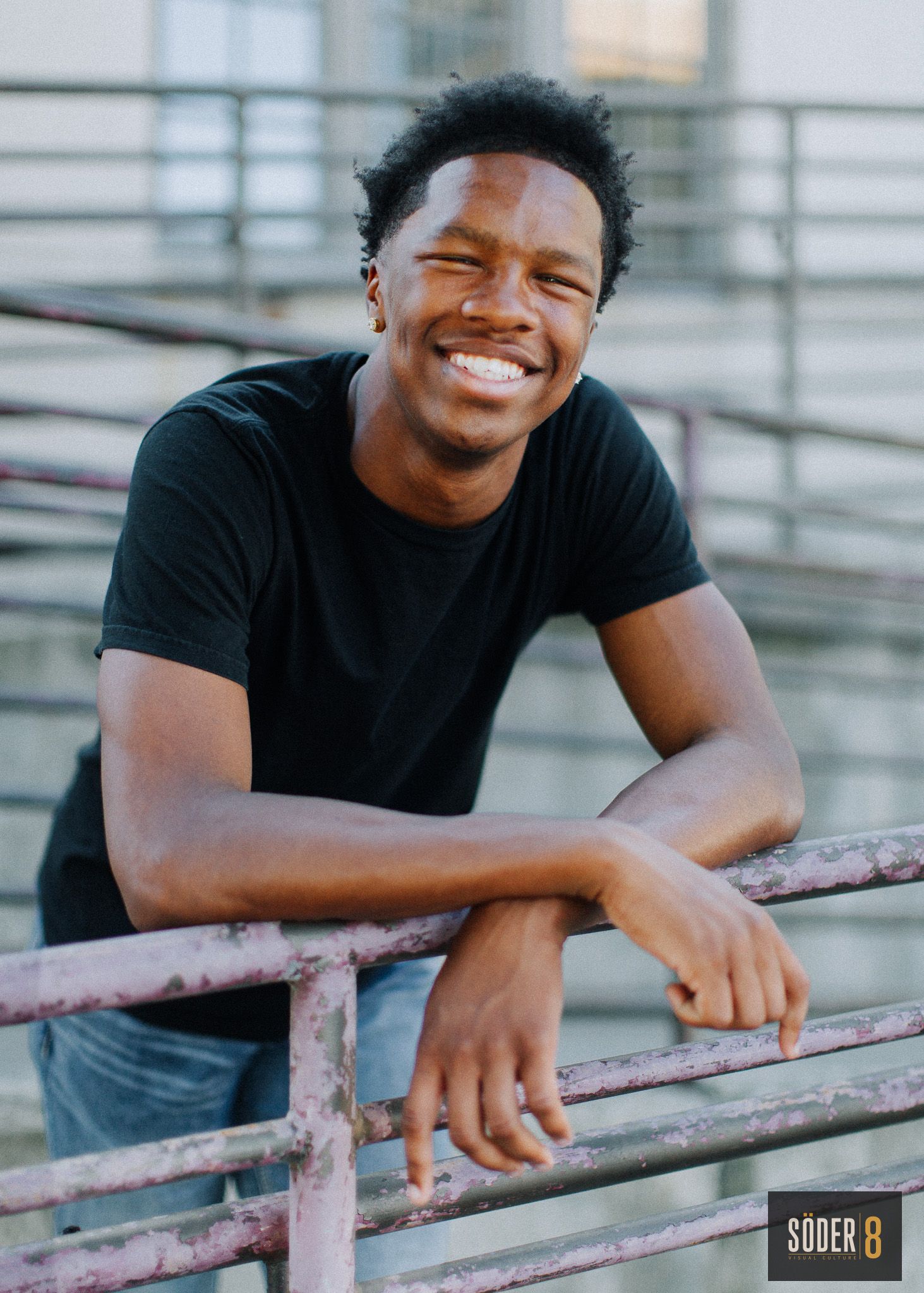 smiling young man leaning against railing