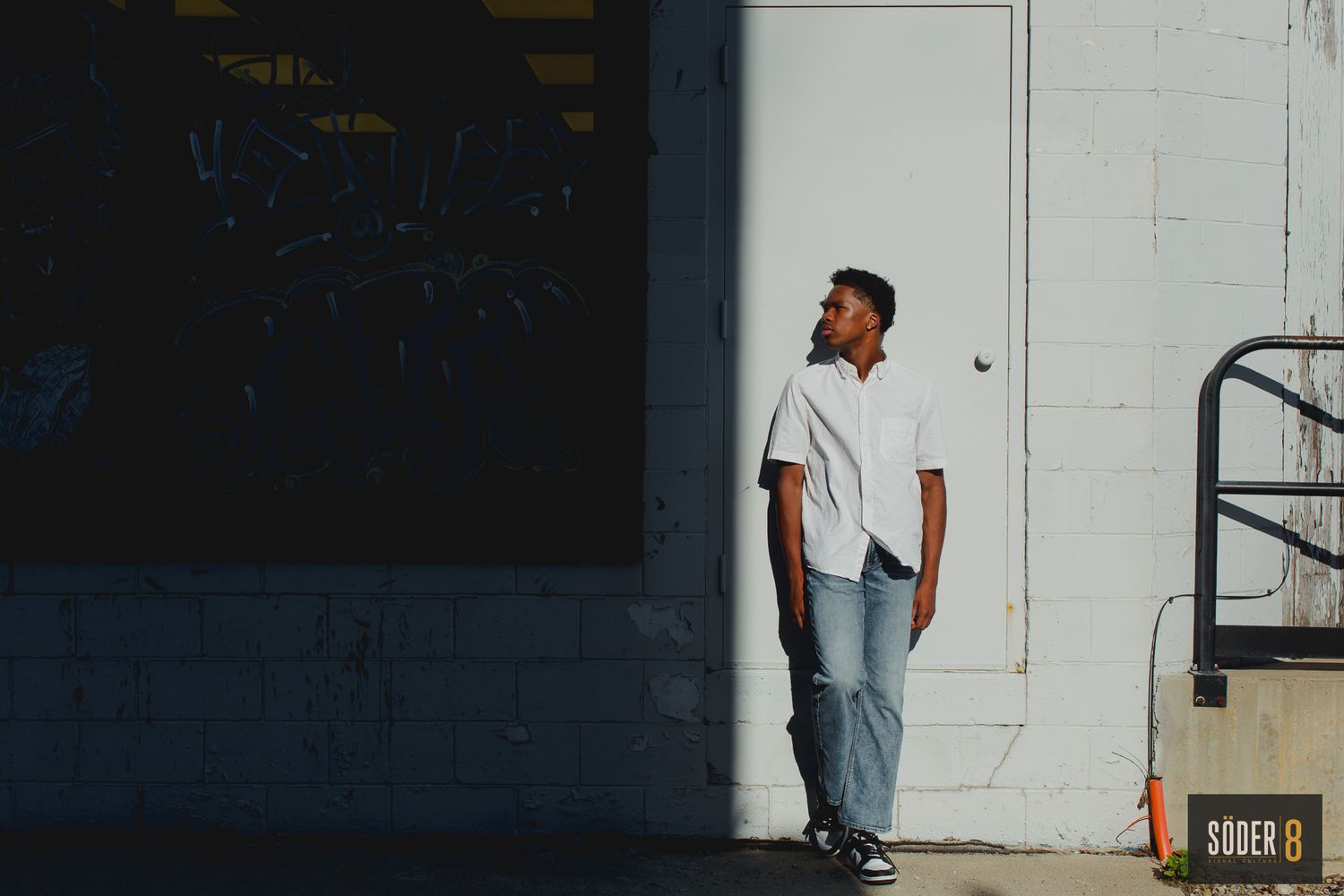 young man in light and shadows against mason city wall
