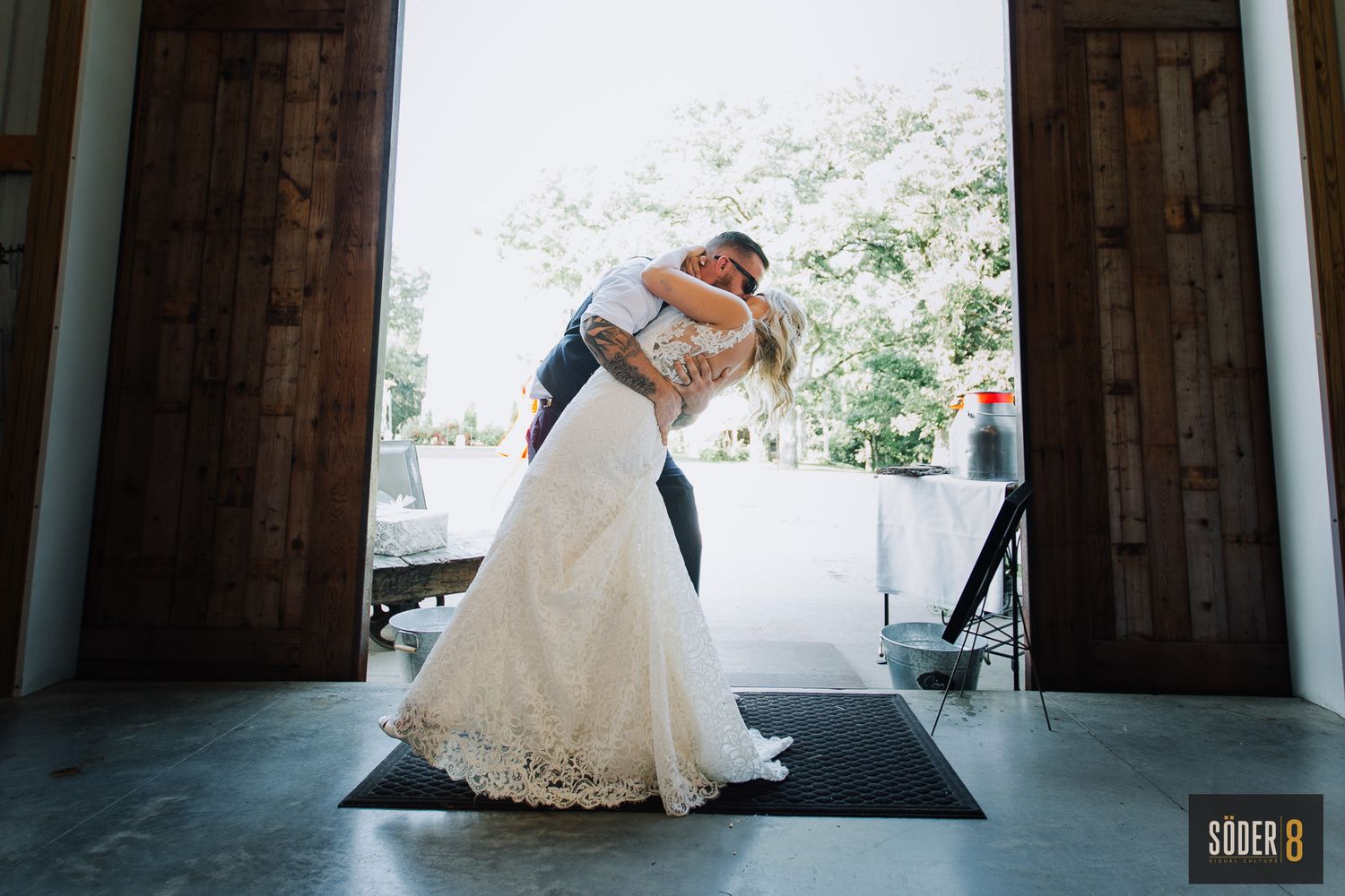 groom and bride embrace at clear lake iowa outdoor barn wedding