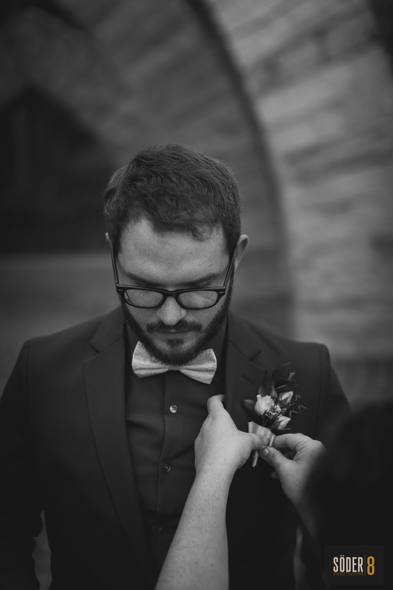 groom getting pinned with bouquet