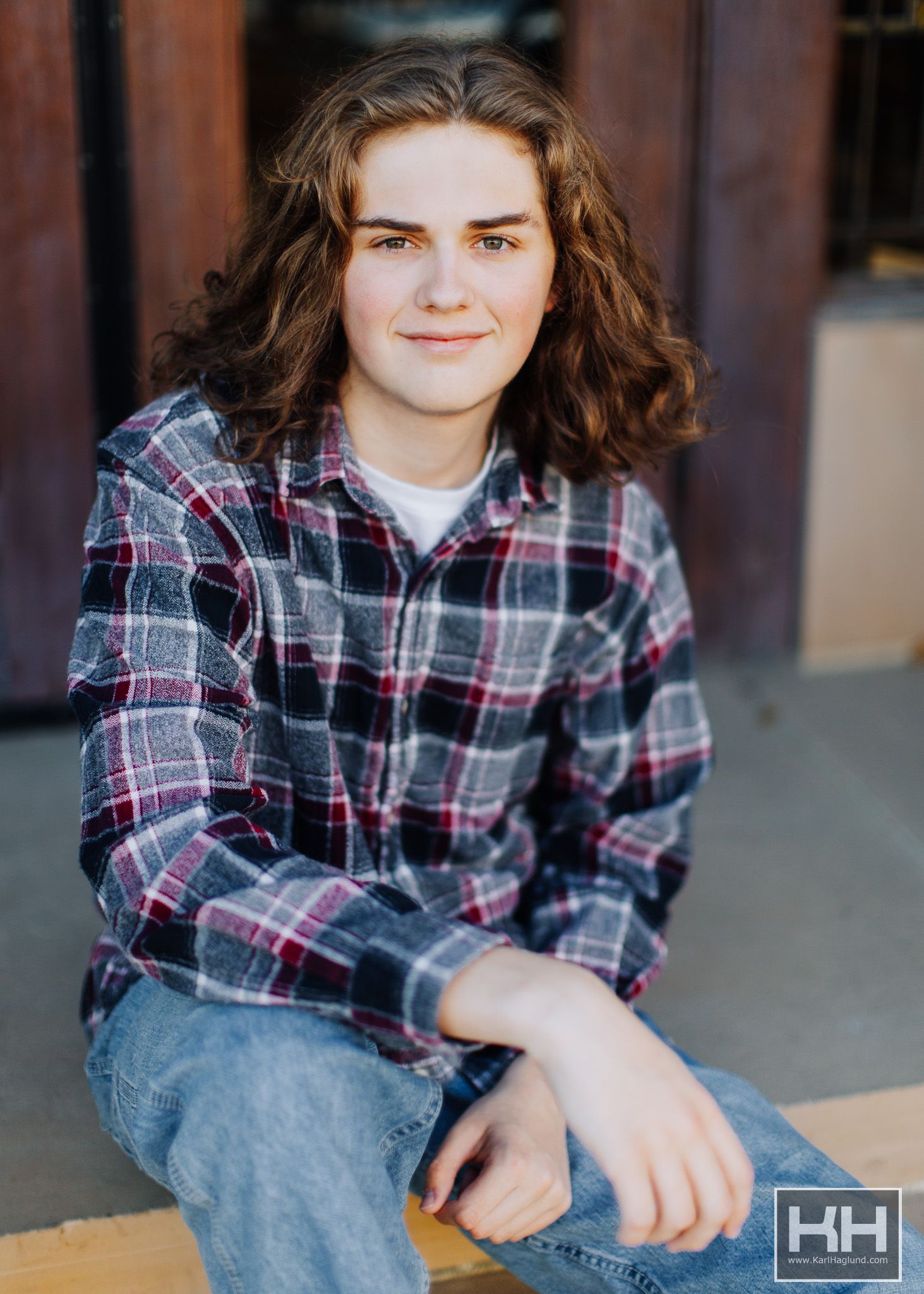 mason city, iowa senior photo. boy with long hair smiling in alleyway