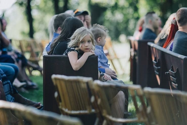 young girl wedding guest looking bored staring at photographer