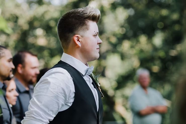 lgbtq groom waiting to see bride walk down aisle during ceremony