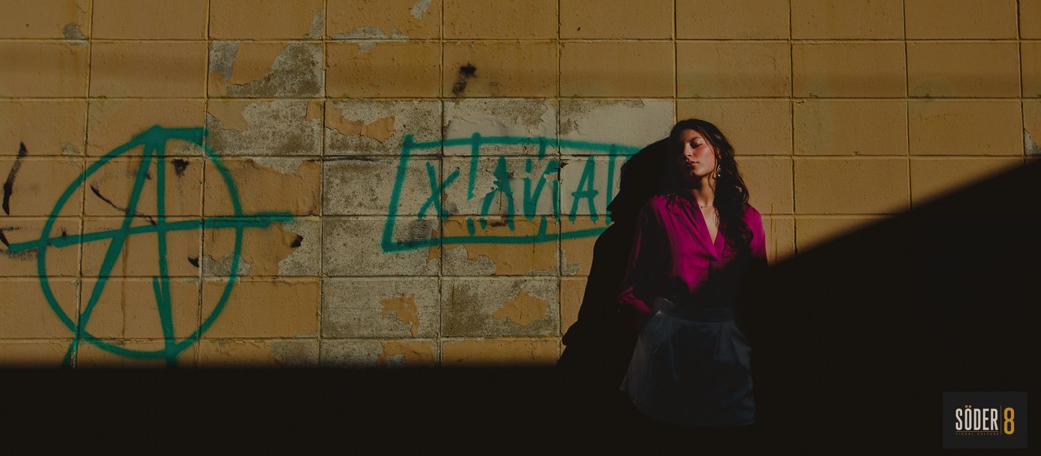 high school senior in clear lake, iowa standing next to a wall in light and shadows with graffiti - soder 8