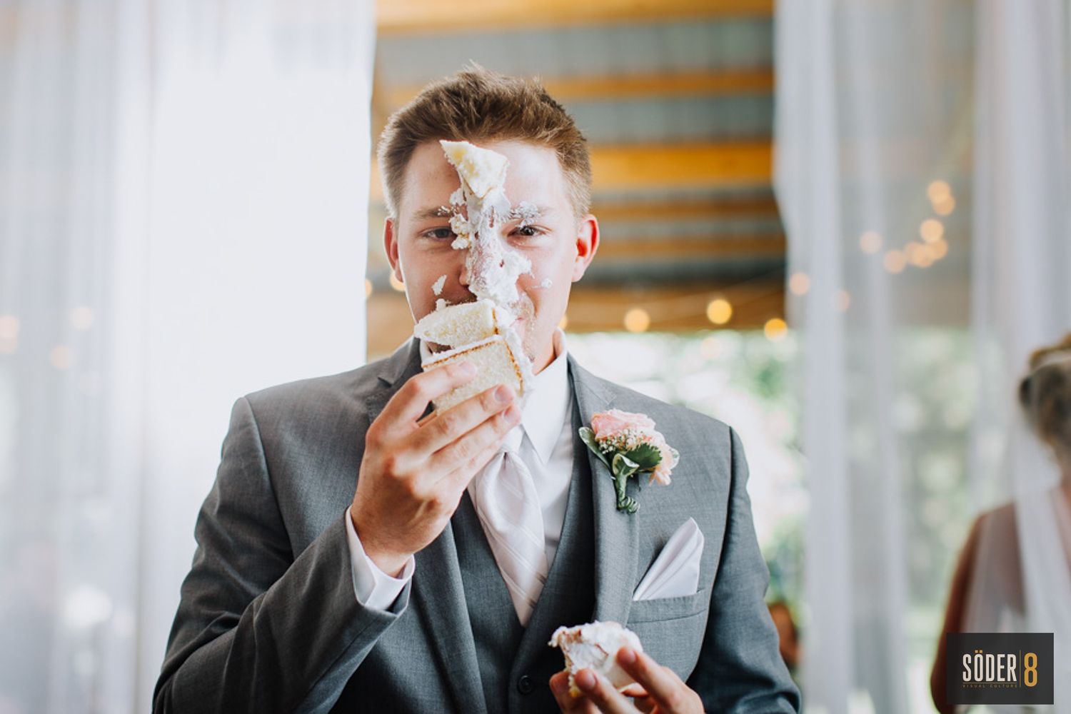groom with cake on his face at wedding reception