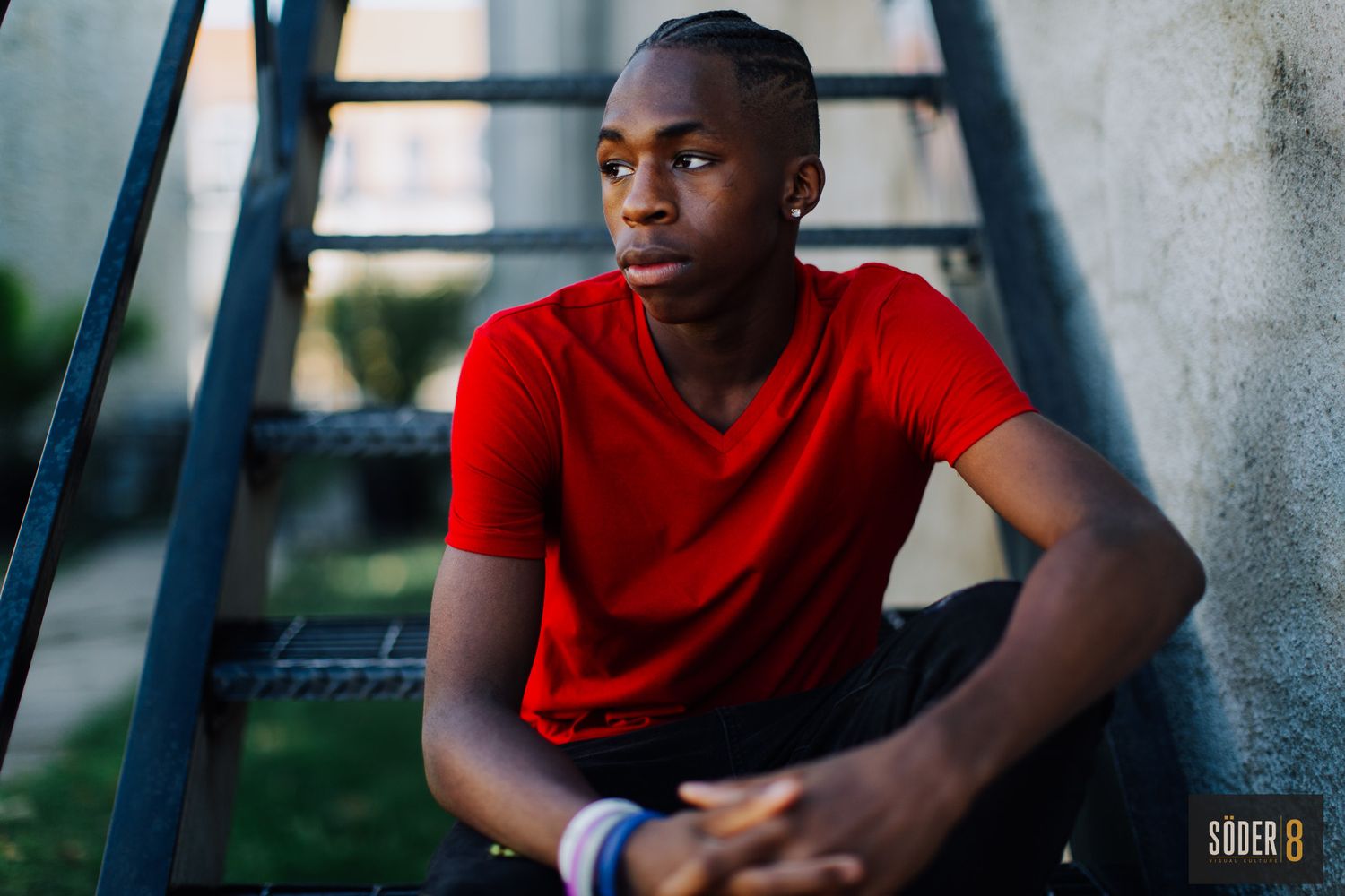 young man on stairs sitting and looking to the right