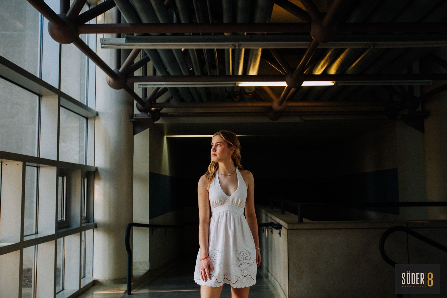 girl standing next to window in shadow and light