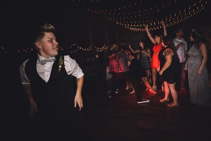 lgbtq groom throwing garter belt to crowd at diamond oak events wedding in clear lake, iowa