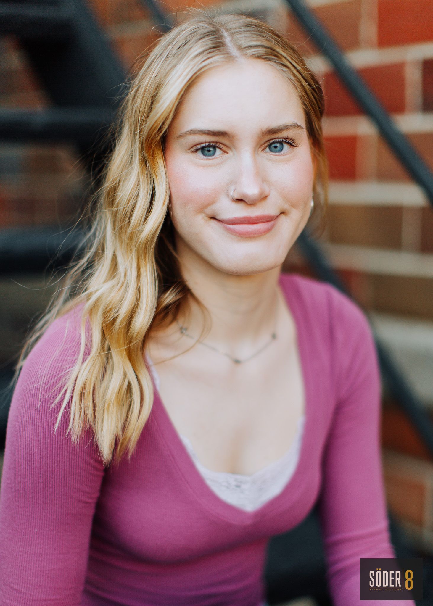 high school girl on stairs next to brick wall