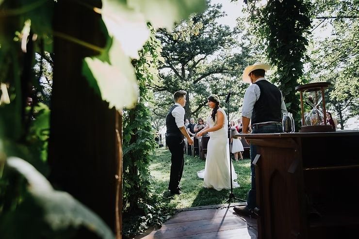 same-sex bride and groom holding hands during outdoor wedding ceremony in northern iowa