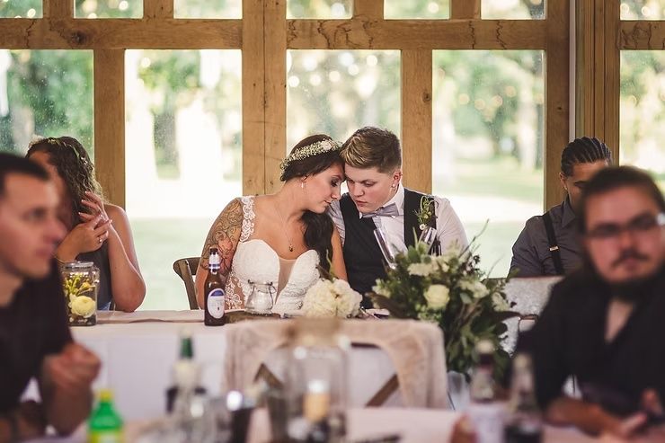 same sex wedding couple at head table talking