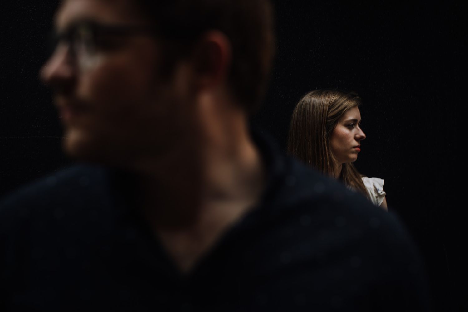 Iowa City engagement session man in blur standing in front of woman in slice of sunlight