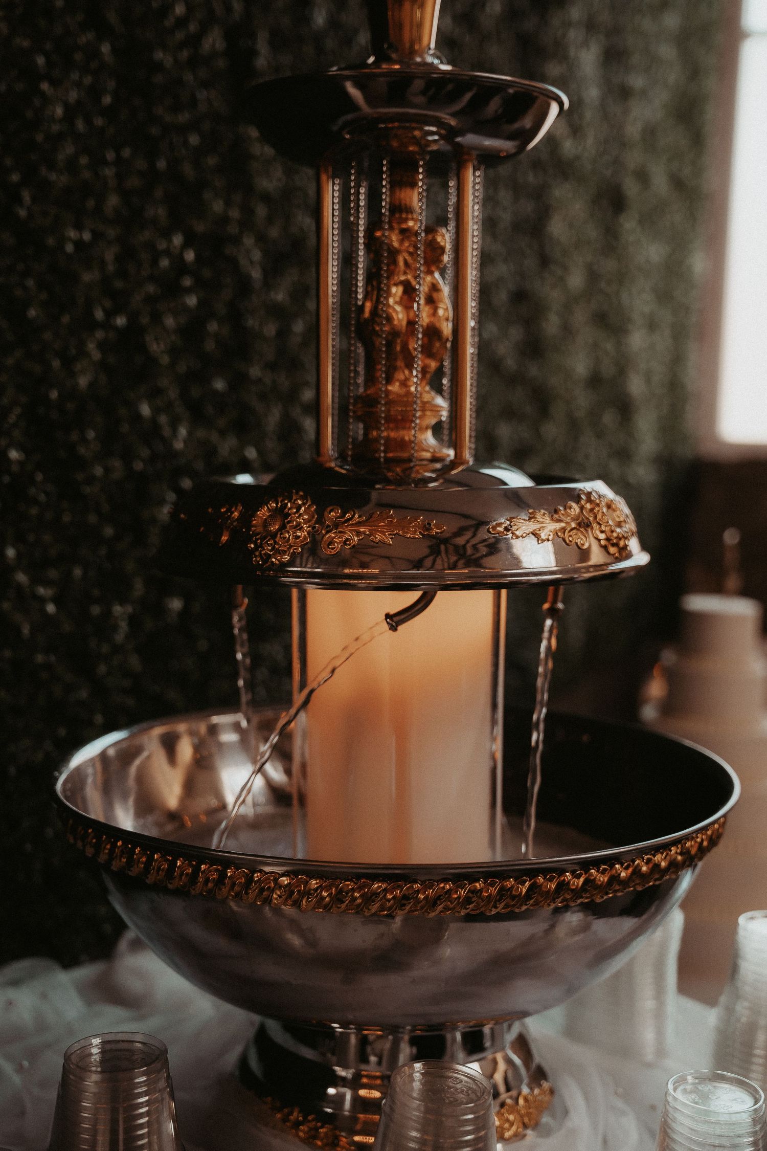 Champagne fountain party display pouring in cascading tiers at an elegant event.