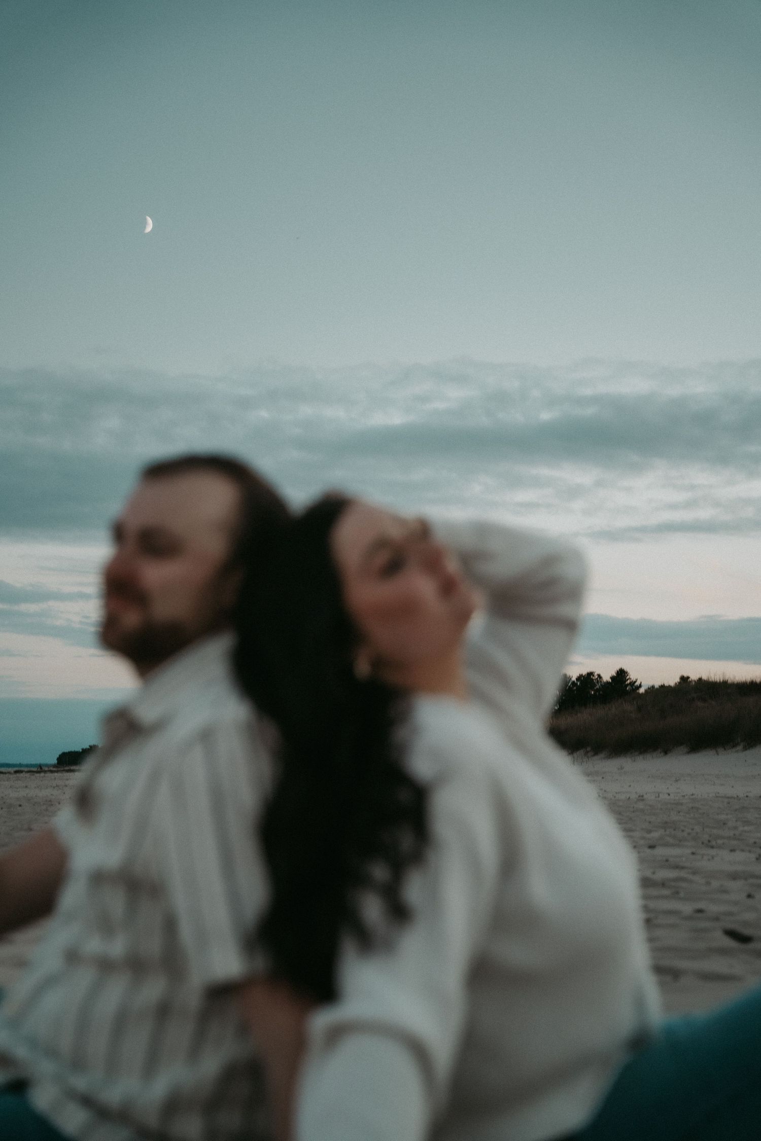 A series of blurred motion shots showing people dancing against a moody evening sky backdrop by the ocean.