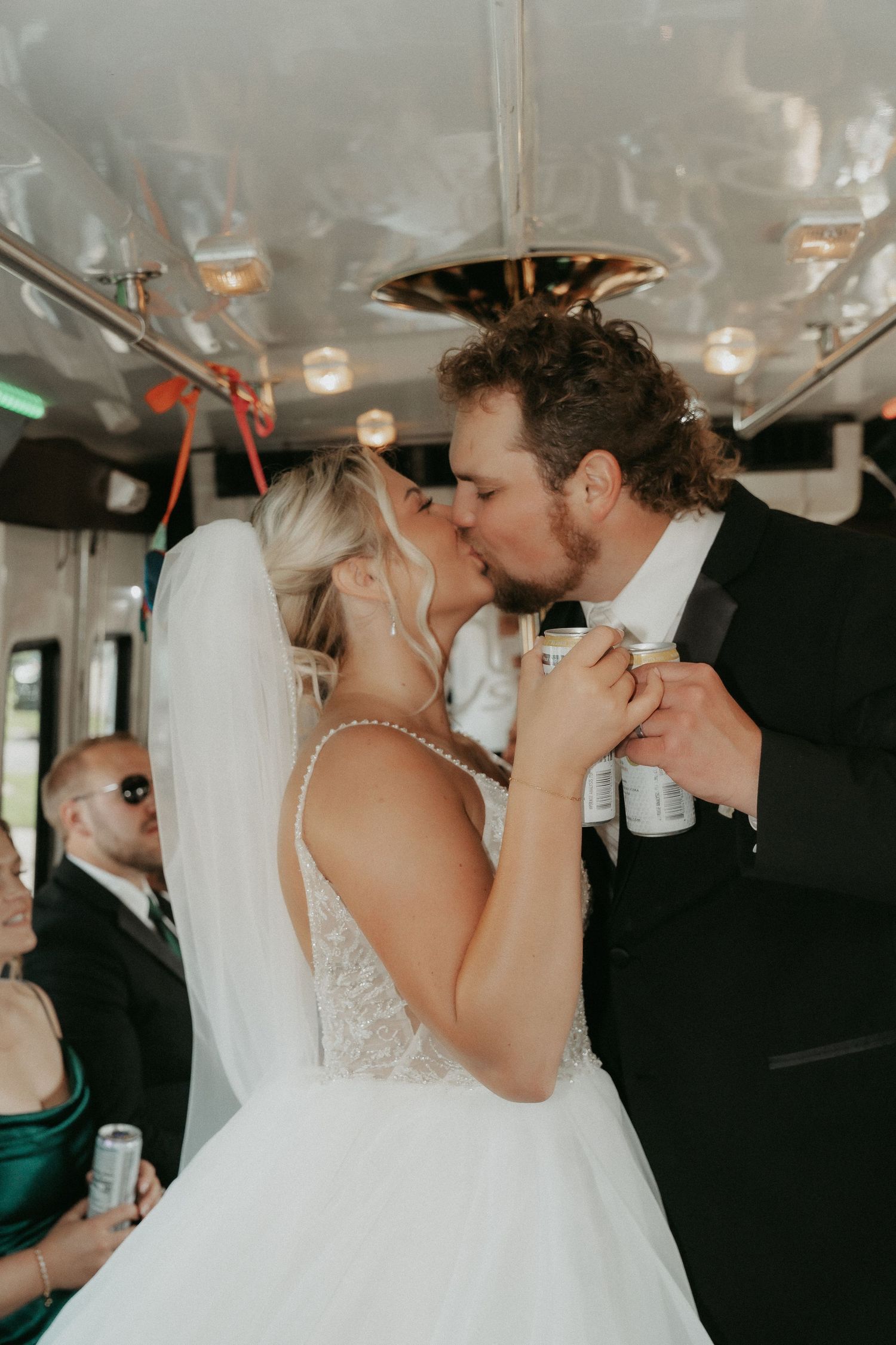 A romantic moment shared between newlyweds dancing together on their wedding day inside a party bus.