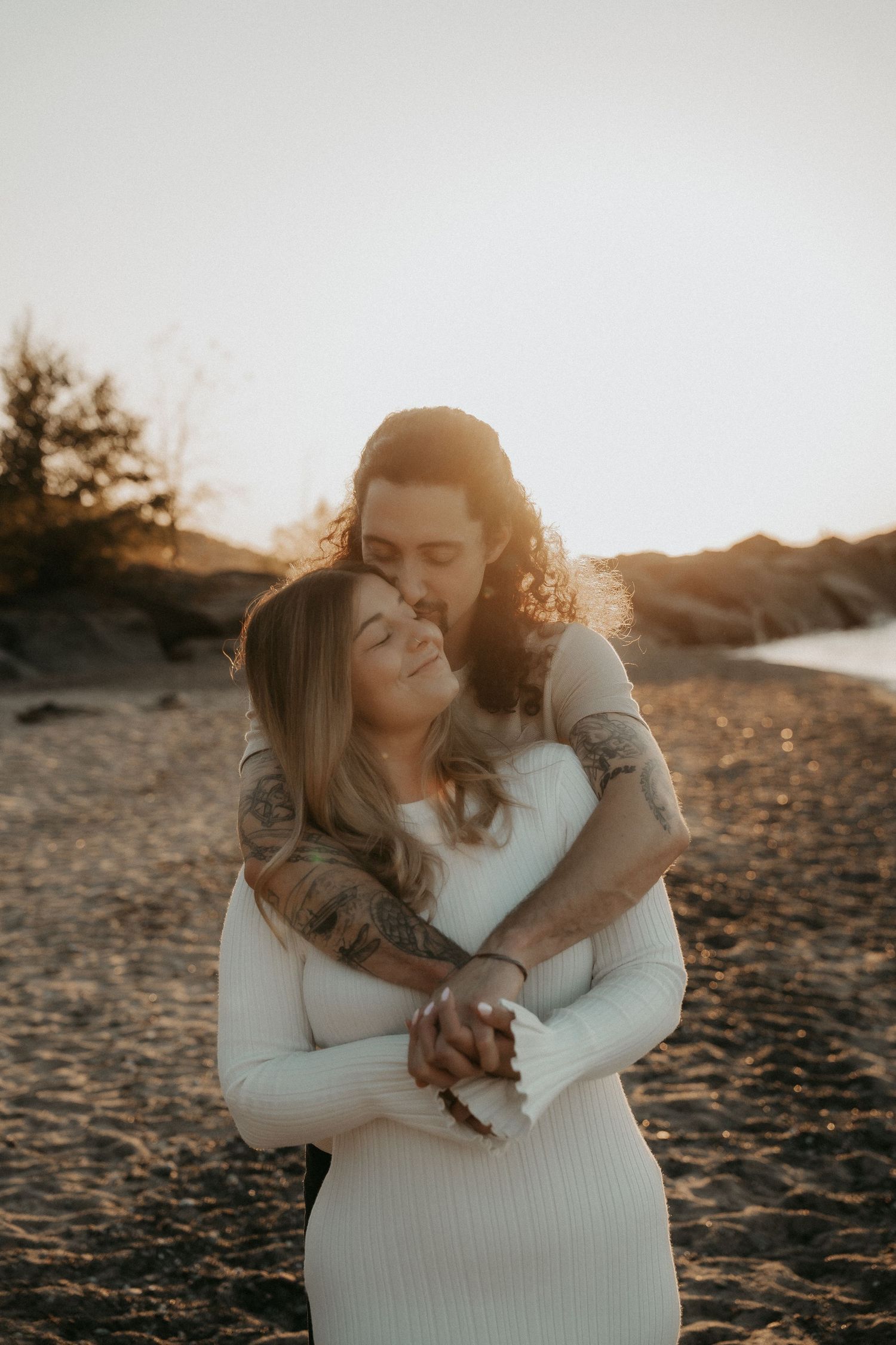 Romantic couple embraces on a sandy beach during golden hour sunset in a series of intimate photos.