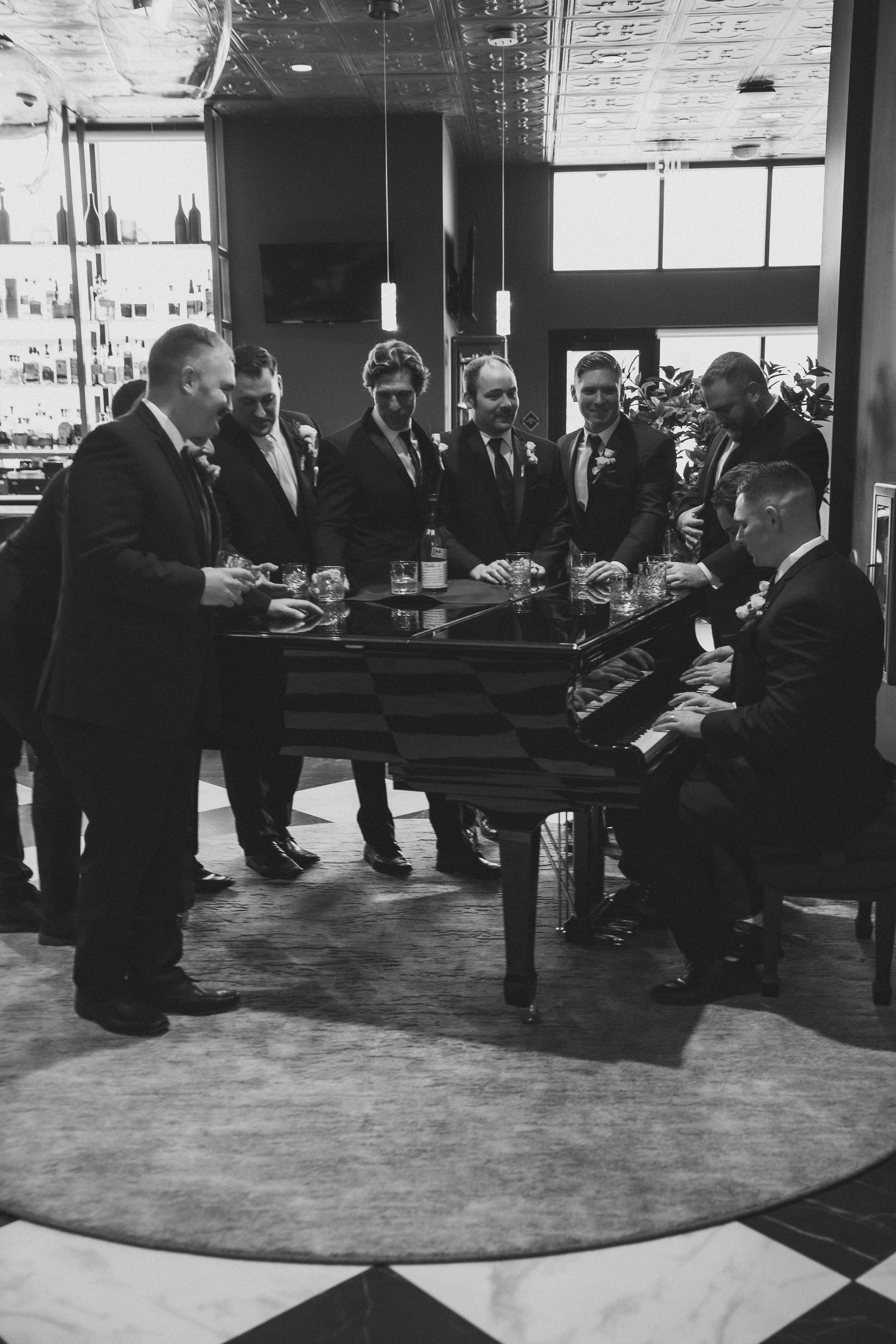 A black and white photo collage showing multiple scenes of businessmen in suits gathered in an office or meeting space.