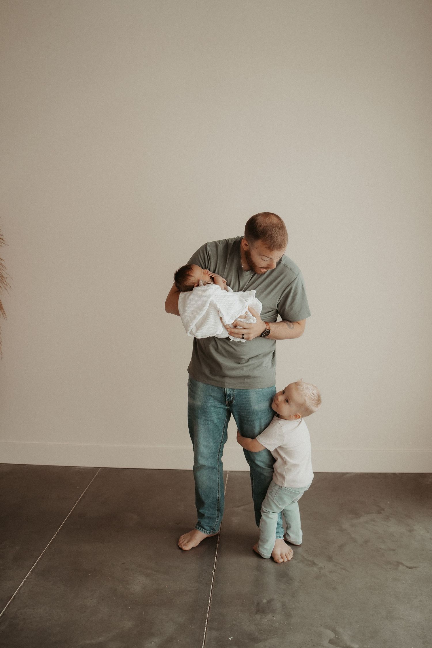 dad holding newborn and son