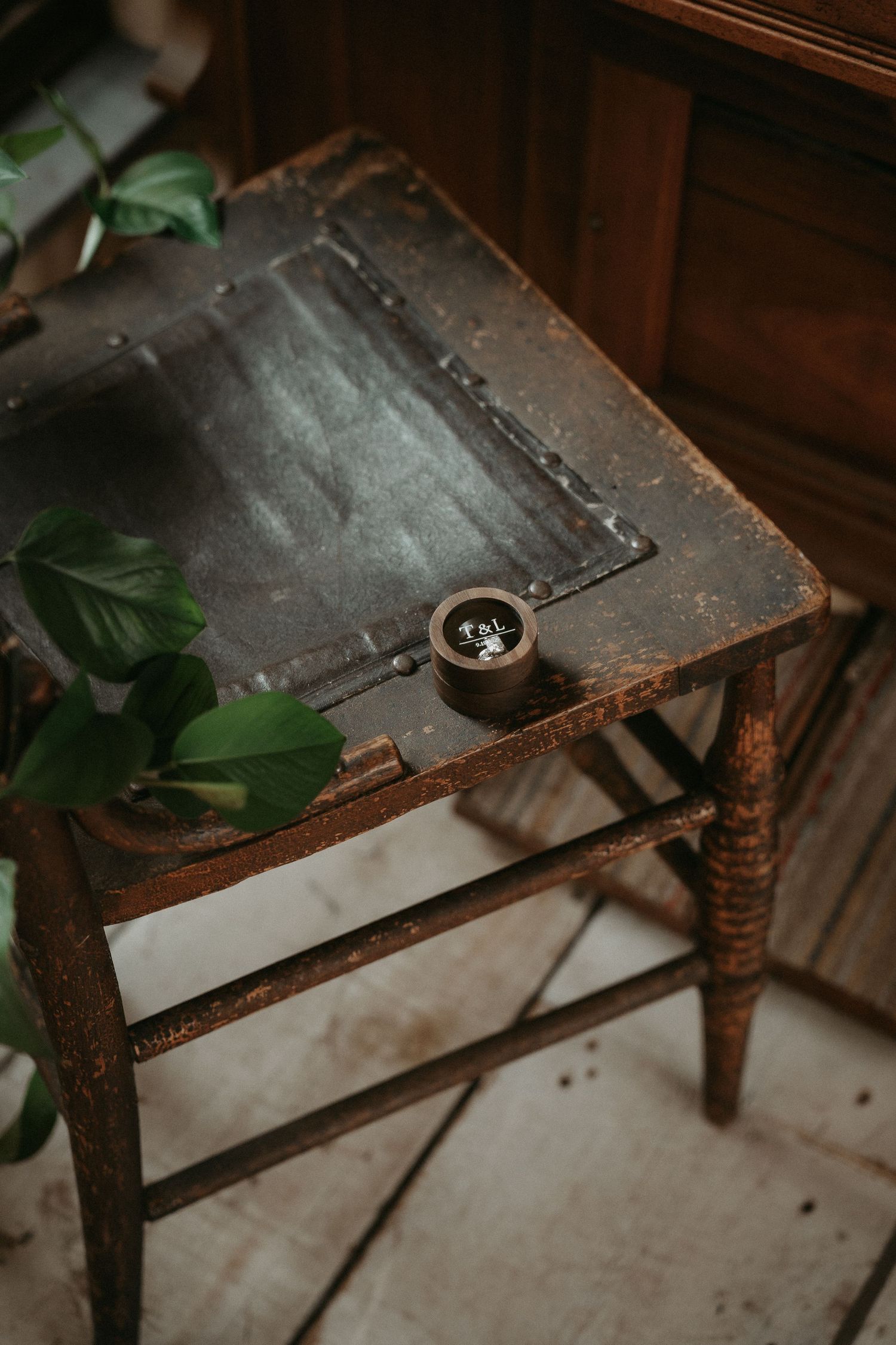 Close-up view of an antique wooden chair with ornate turned legs and worn leather upholstery.