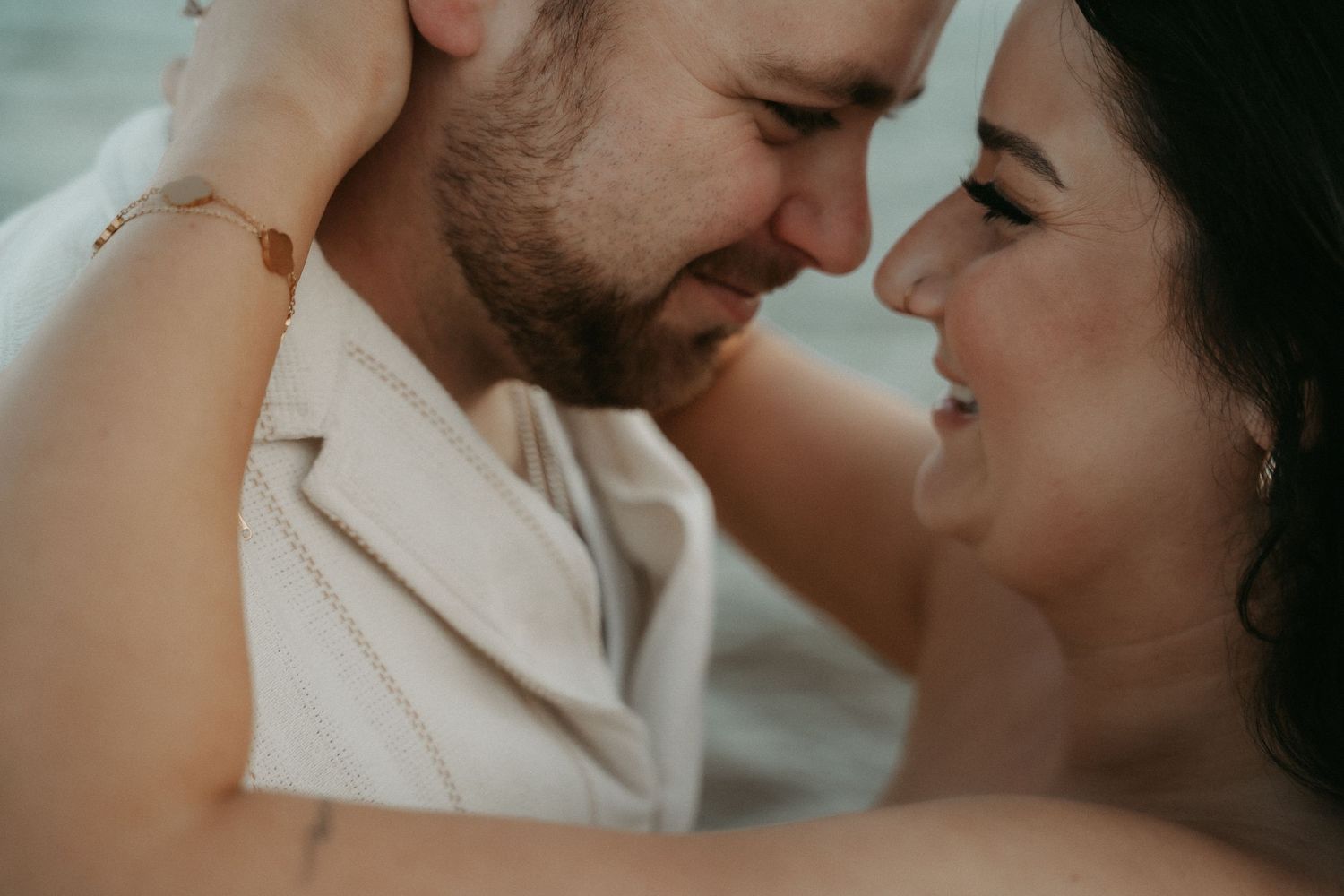 A romantic couple in white clothing shares intimate moments in a series of close-up photos.