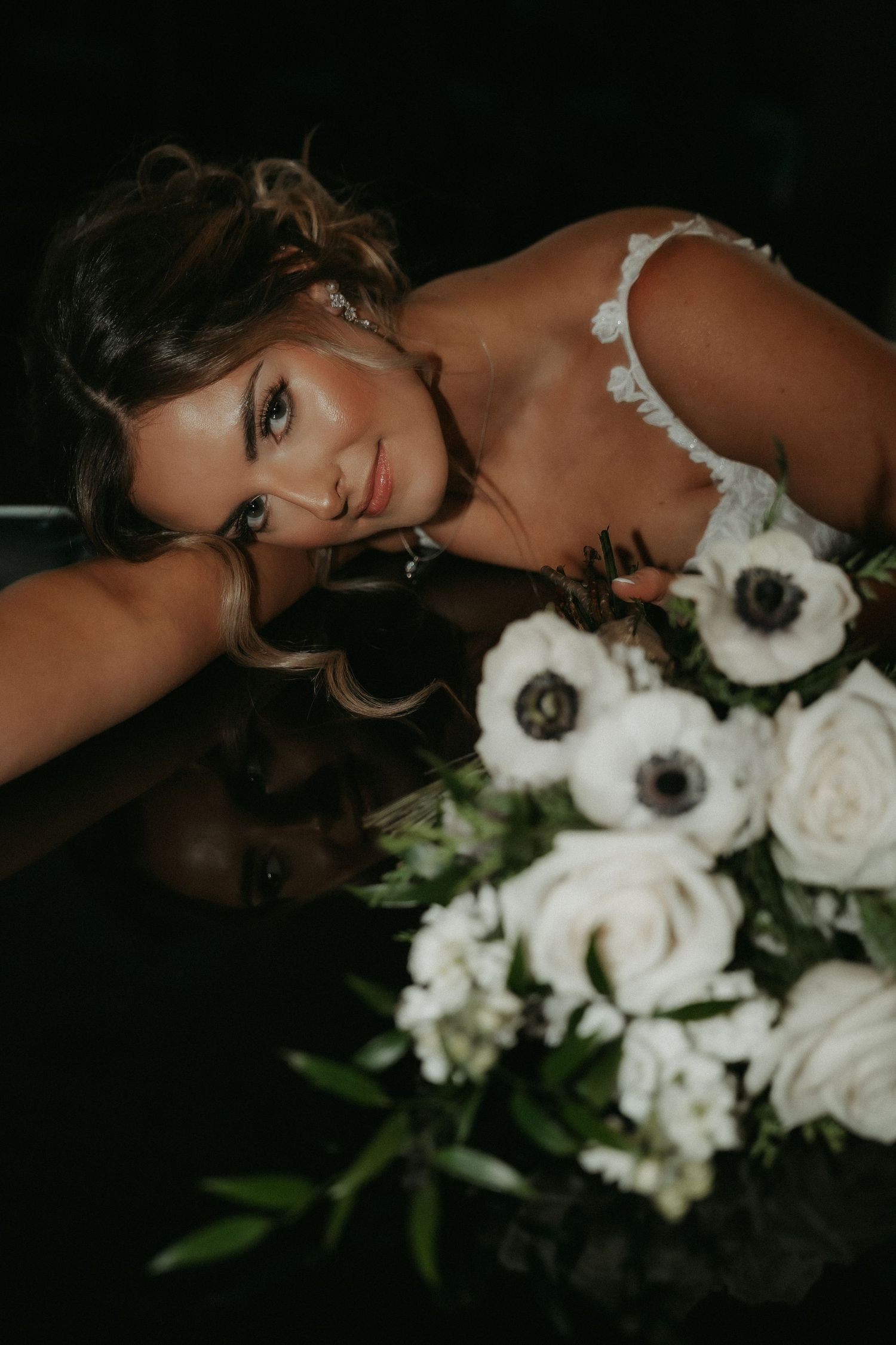 Artistic boudoir photo series featuring white roses and dramatic lighting against a dark background.
