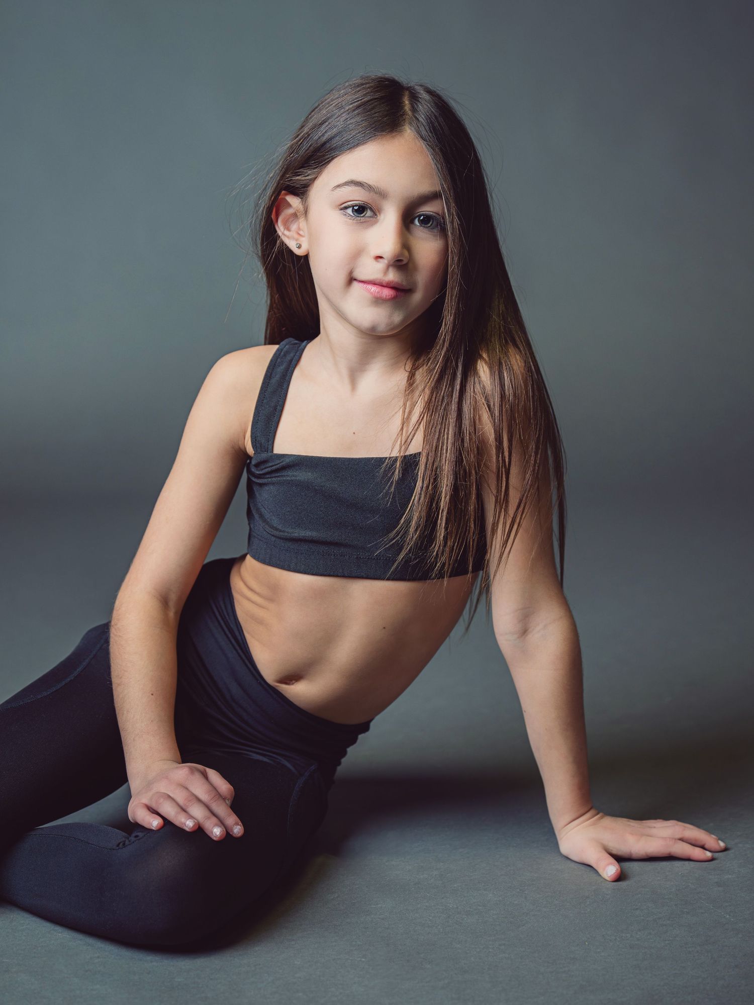 A series of artistic portraits showing a person in a black outfit posing gracefully against a dark gray backdrop.