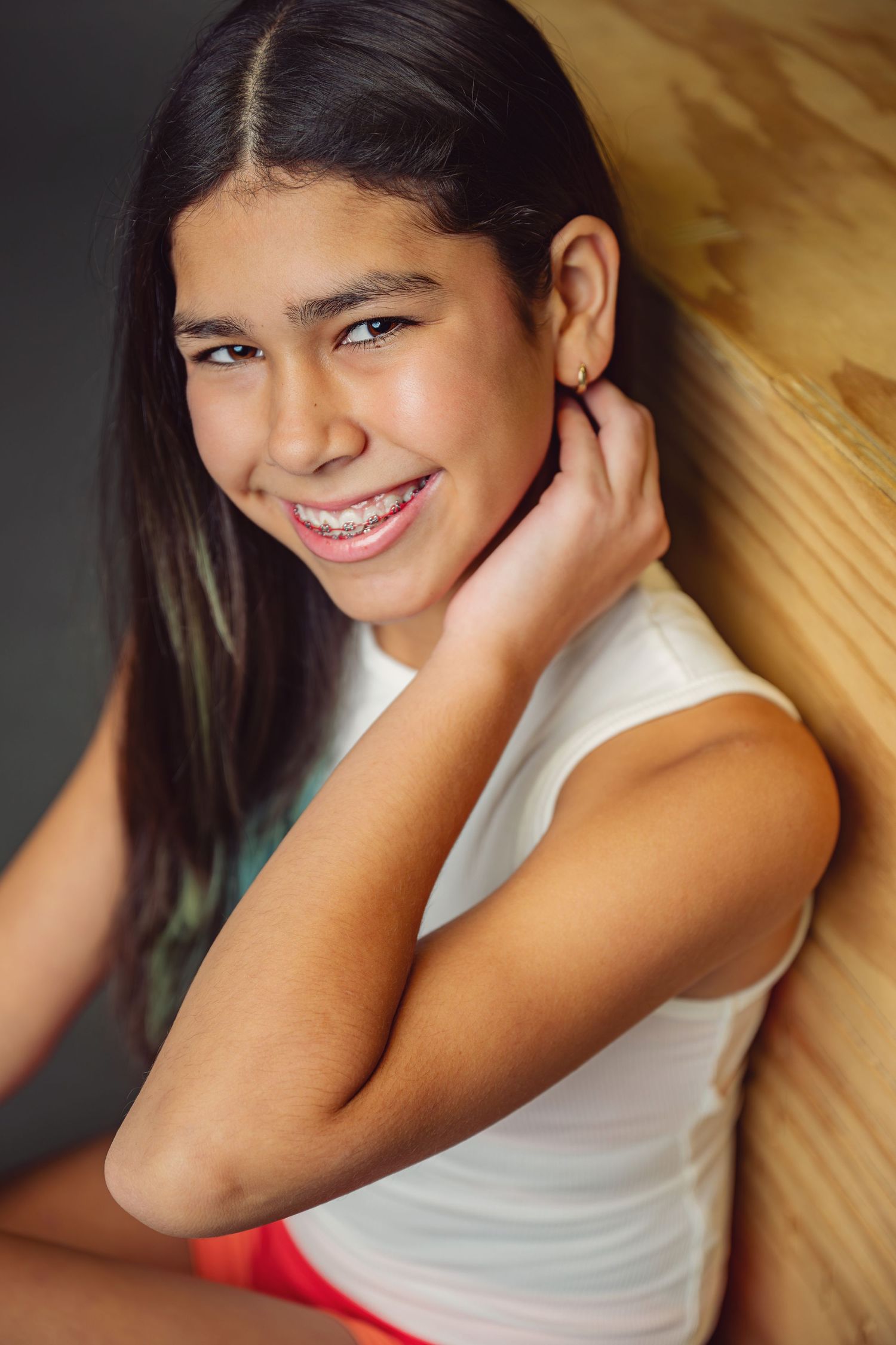 A series of candid portraits showing joyful expressions and natural poses against a warm wooden background.