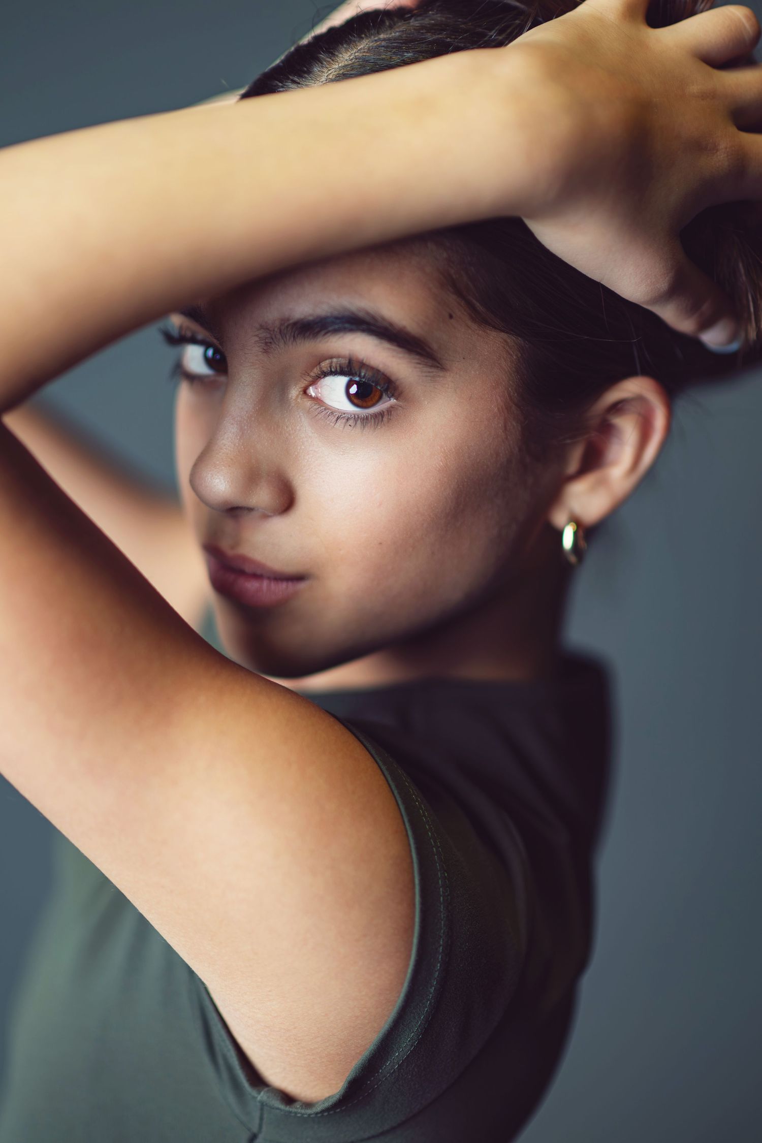 A series of artistic profile portraits showing a figure in a black top against a dark background.