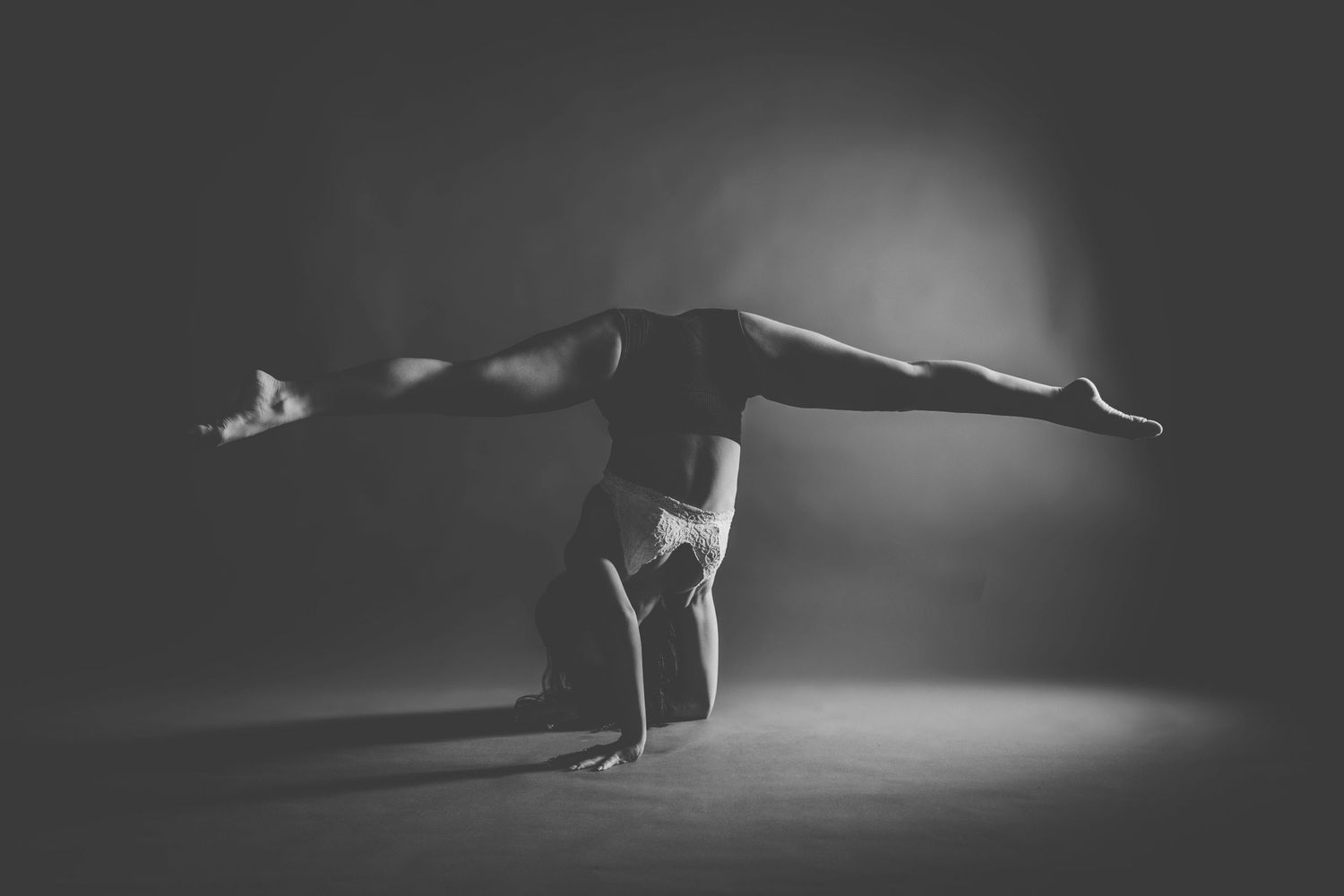 A dramatic black and white series of dance movements captured in low light with strong shadows and silhouettes.