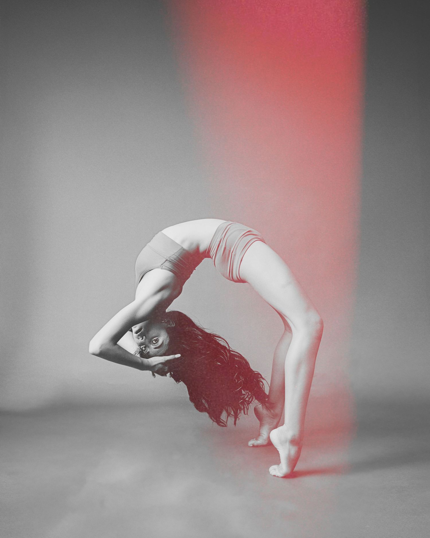 Contemporary dancer in motion captured with red light accent and motion blur effects.