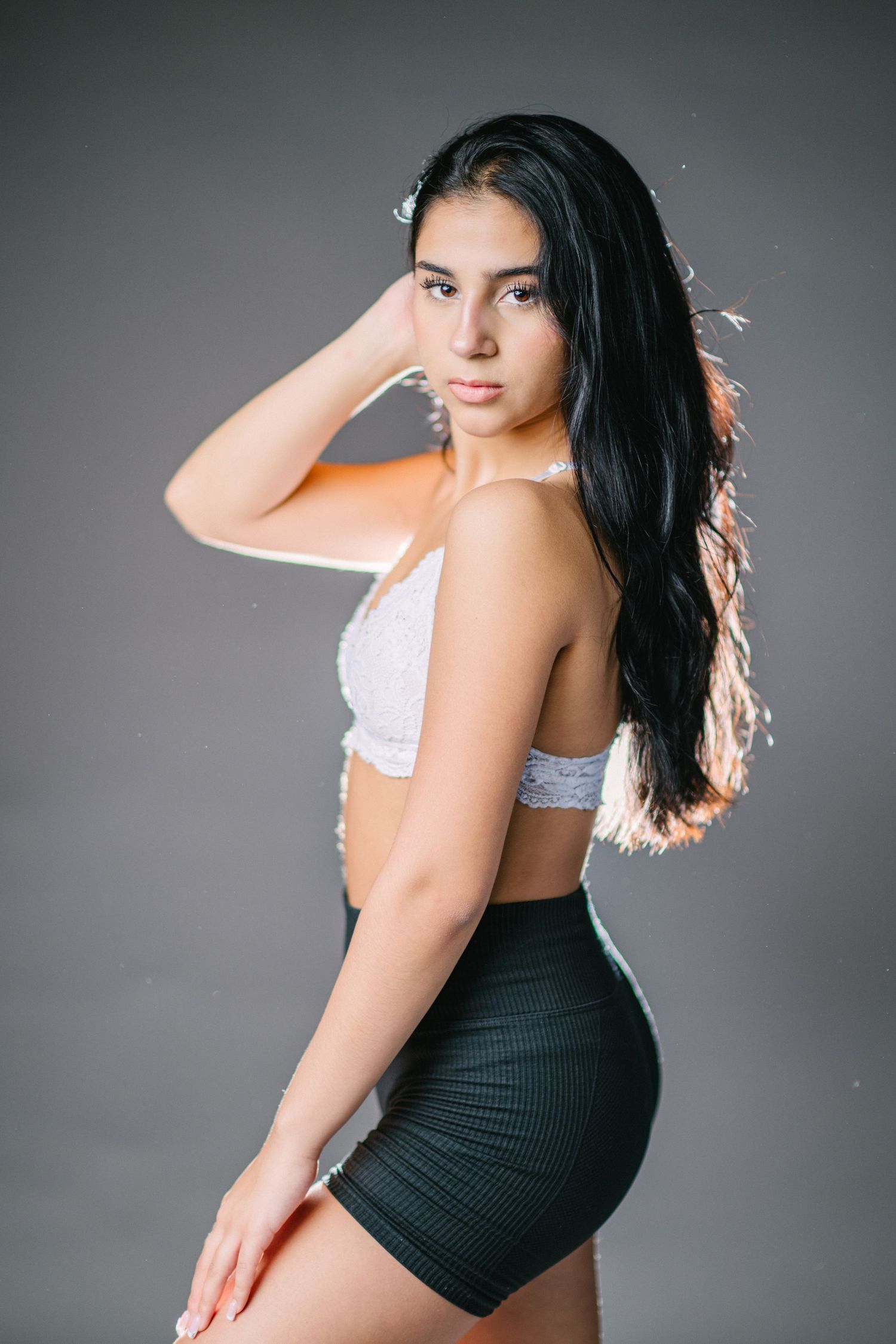 A series of fashion portraits showing a woman in black and white attire posing against a gray studio backdrop.