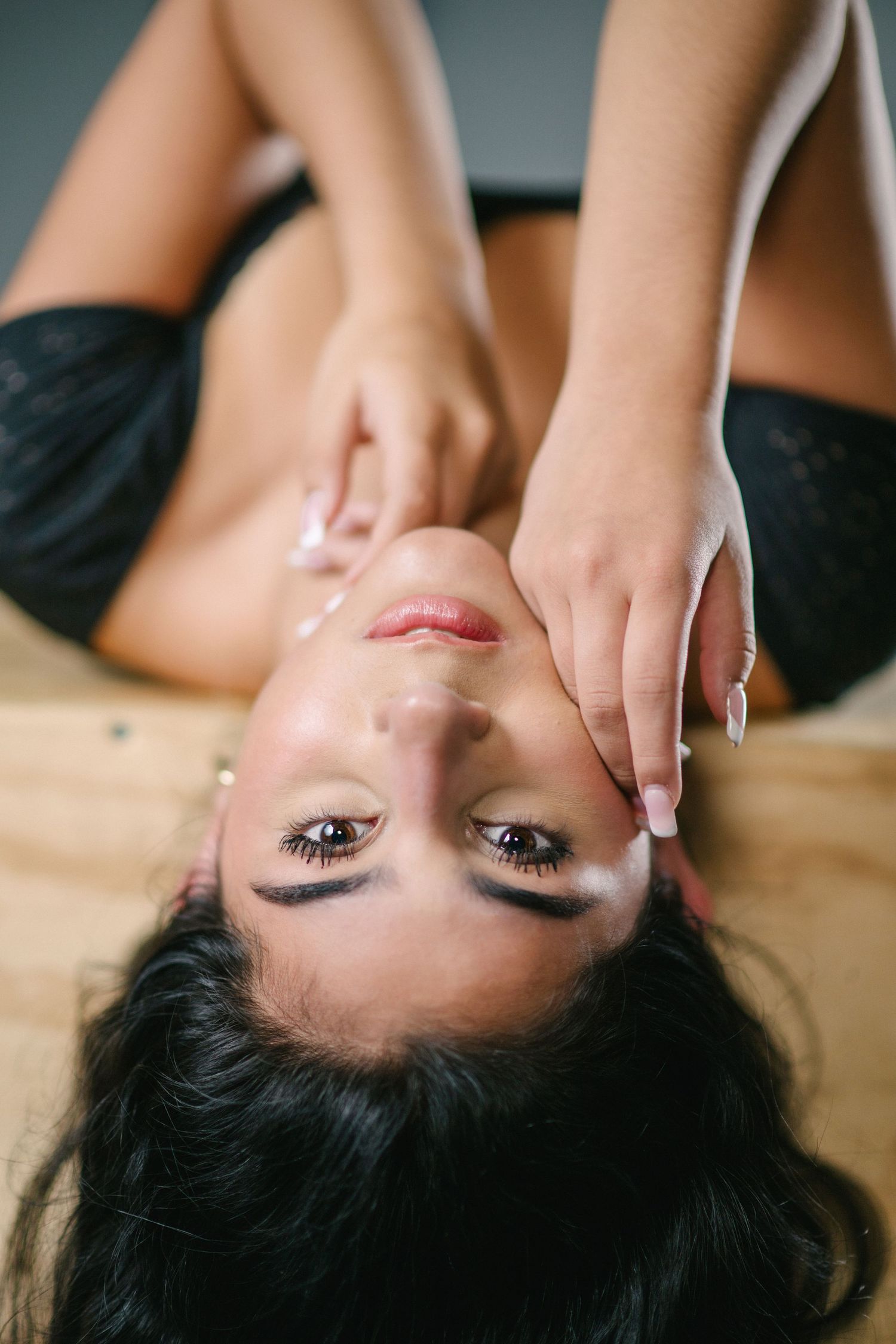 A series of beauty portraits showing a woman with dark hair lying down against a wooden surface.
