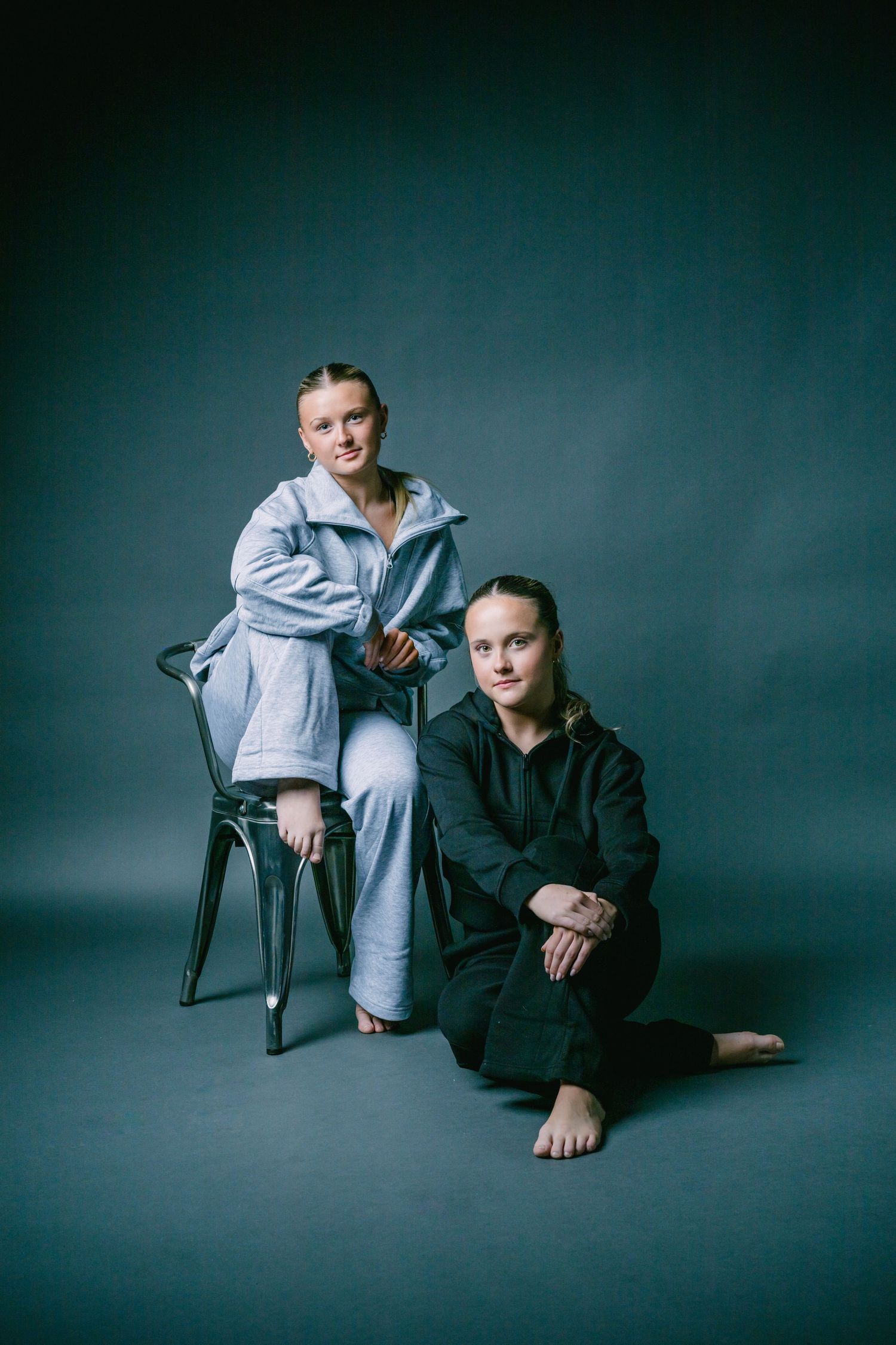 Professional portrait session showing figure in black and white clothing against dark teal backdrop in various poses.