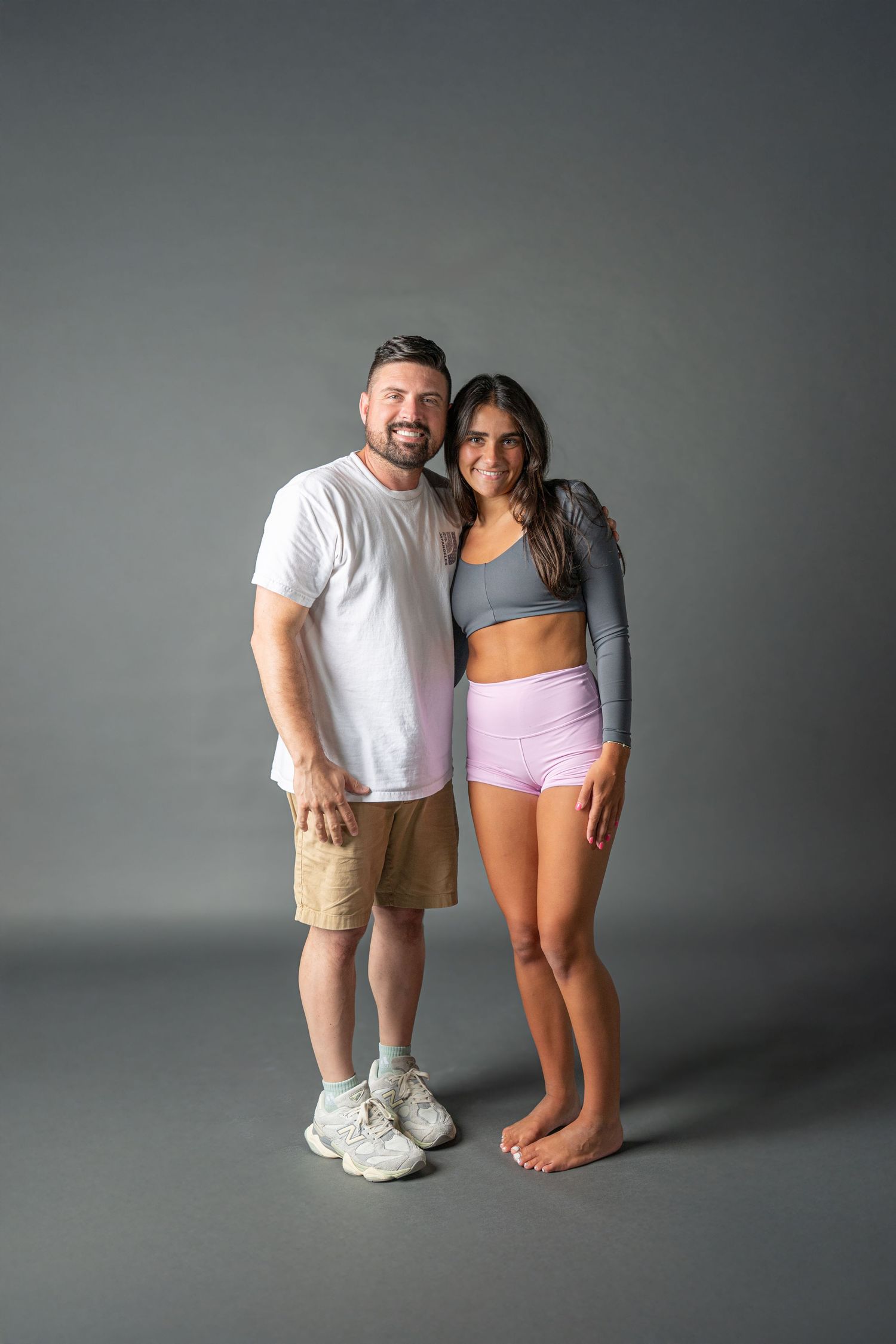 A series of four artistic studio photos showing a couple posing together against a gray background.