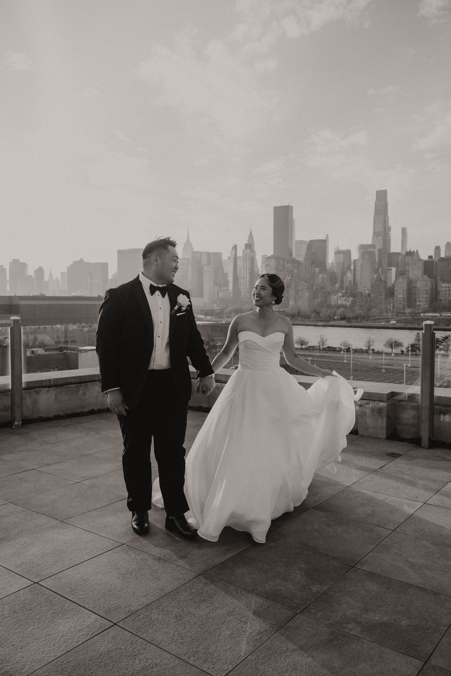 Black and white wedding photos show a couple on a rooftop terrace with the New York City skyline in the background.