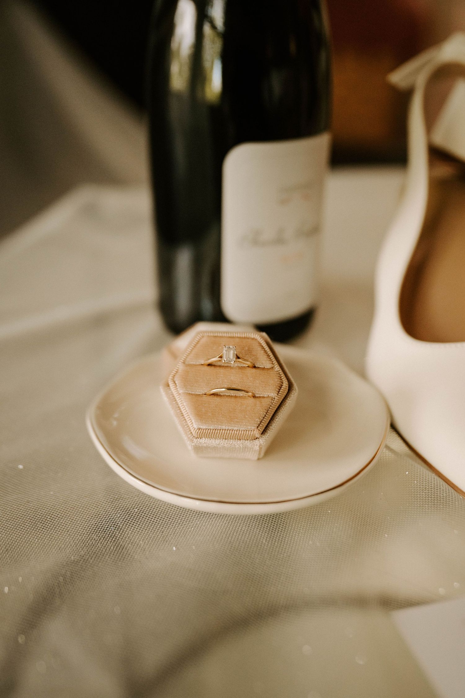 Small wooden place card holders in hexagon shape sit on white plates at an elegant table setting.