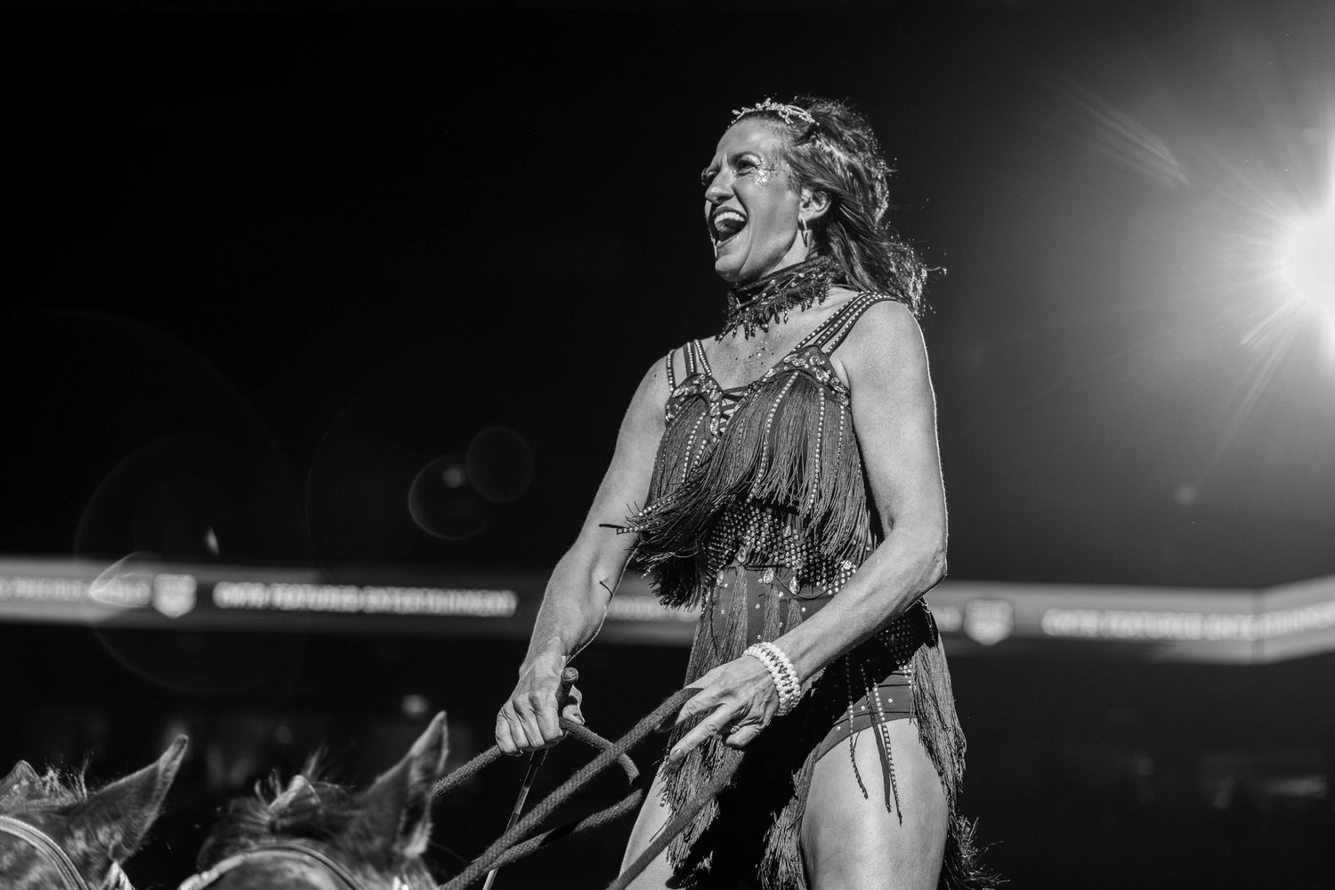 A dramatic black and white performance photo of an energetic stage performance in intense lighting.