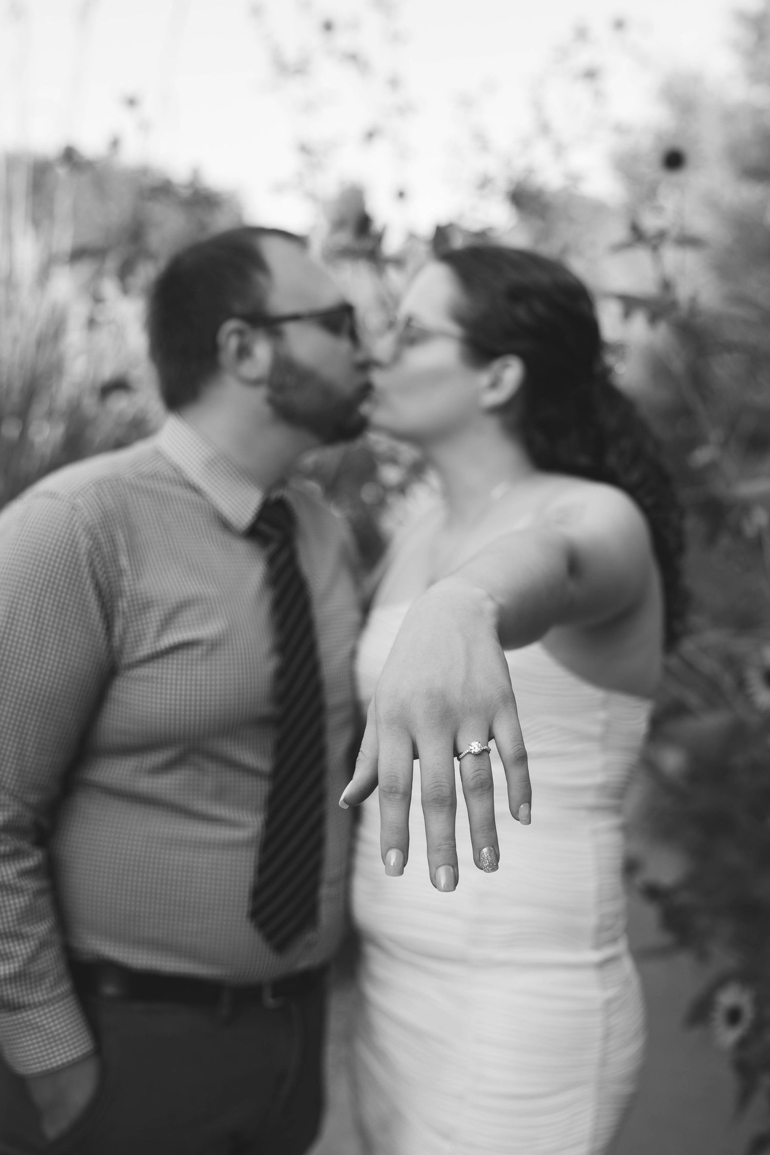 A series of black and white photos showing close-up details of two people dressed in wedding attire exchanging romantic moments.