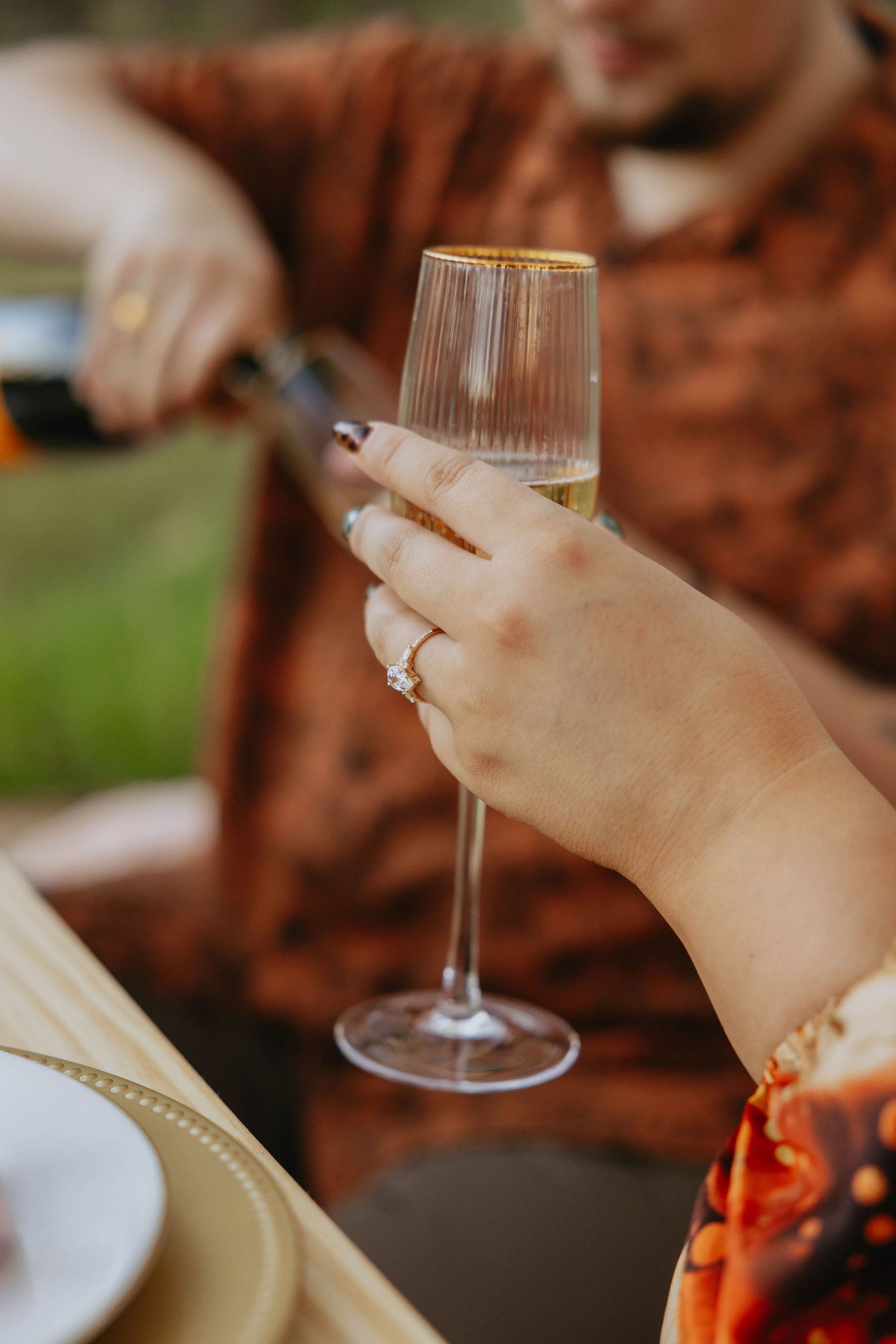 Close-up shots of hands holding wine glasses during a social gathering or dinner party.