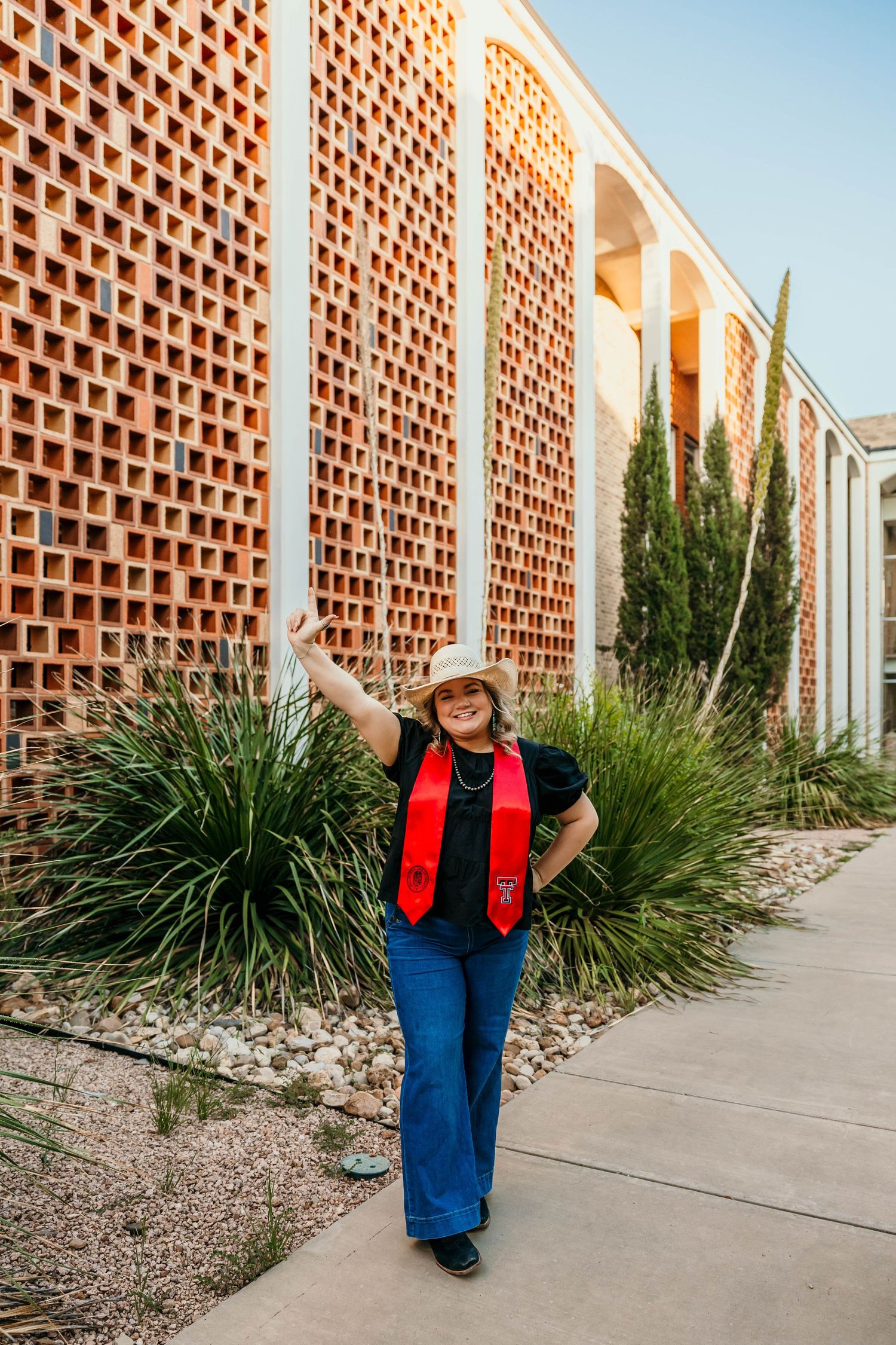 A series of images along a walkway with terracotta brick walls and desert landscaping plants.