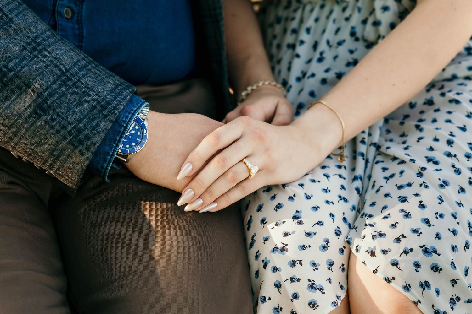 Close-up sequence of hands gently resting on a blue and white floral patterned surface.