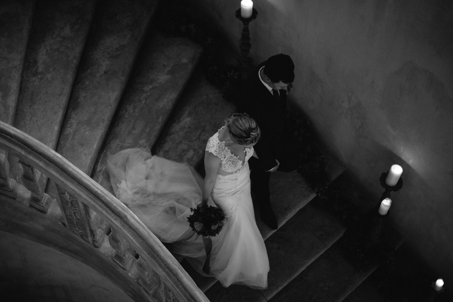 Artistic overhead shot of a wedding couple descending a candlelit staircase at chateau de moissac.