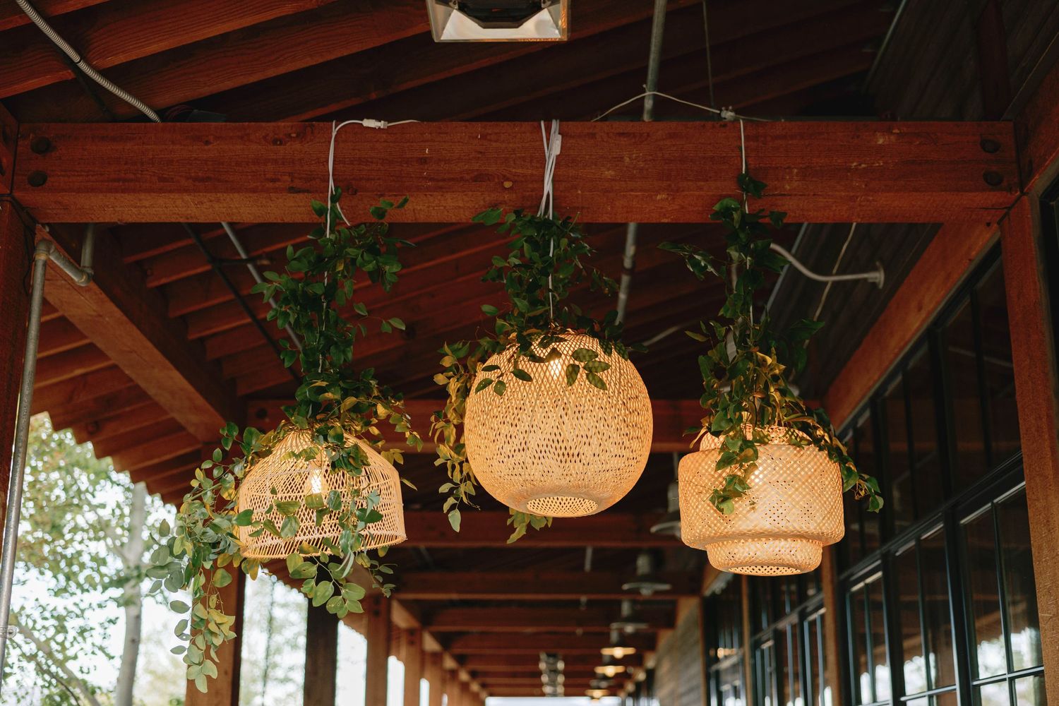 A covered outdoor patio decorated with hanging paper lanterns and string lights creates a cozy ambiance.