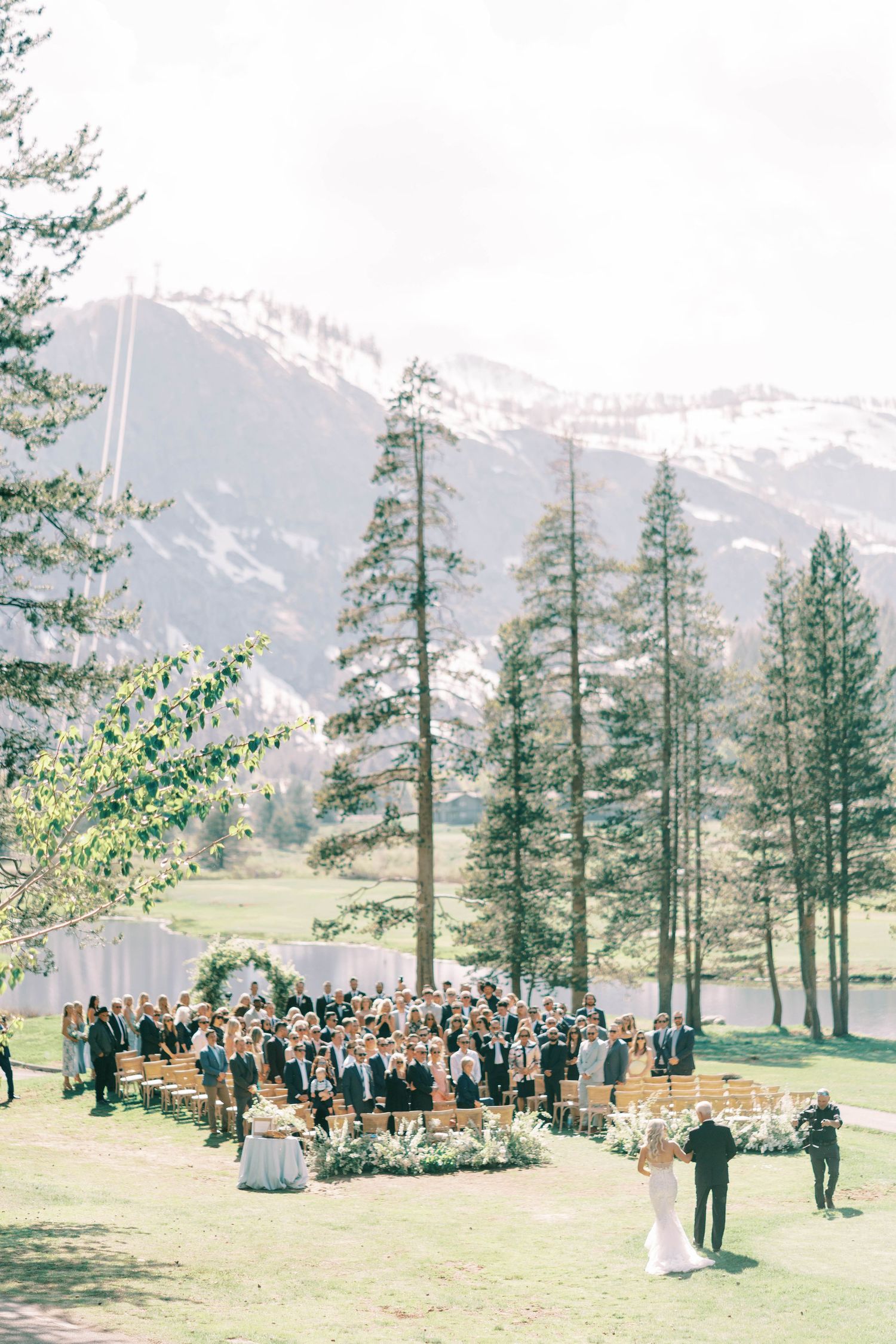 Mountain wedding ceremony setup with evergreen trees and snow-capped peaks in the background at everline resort in lake tahoe.