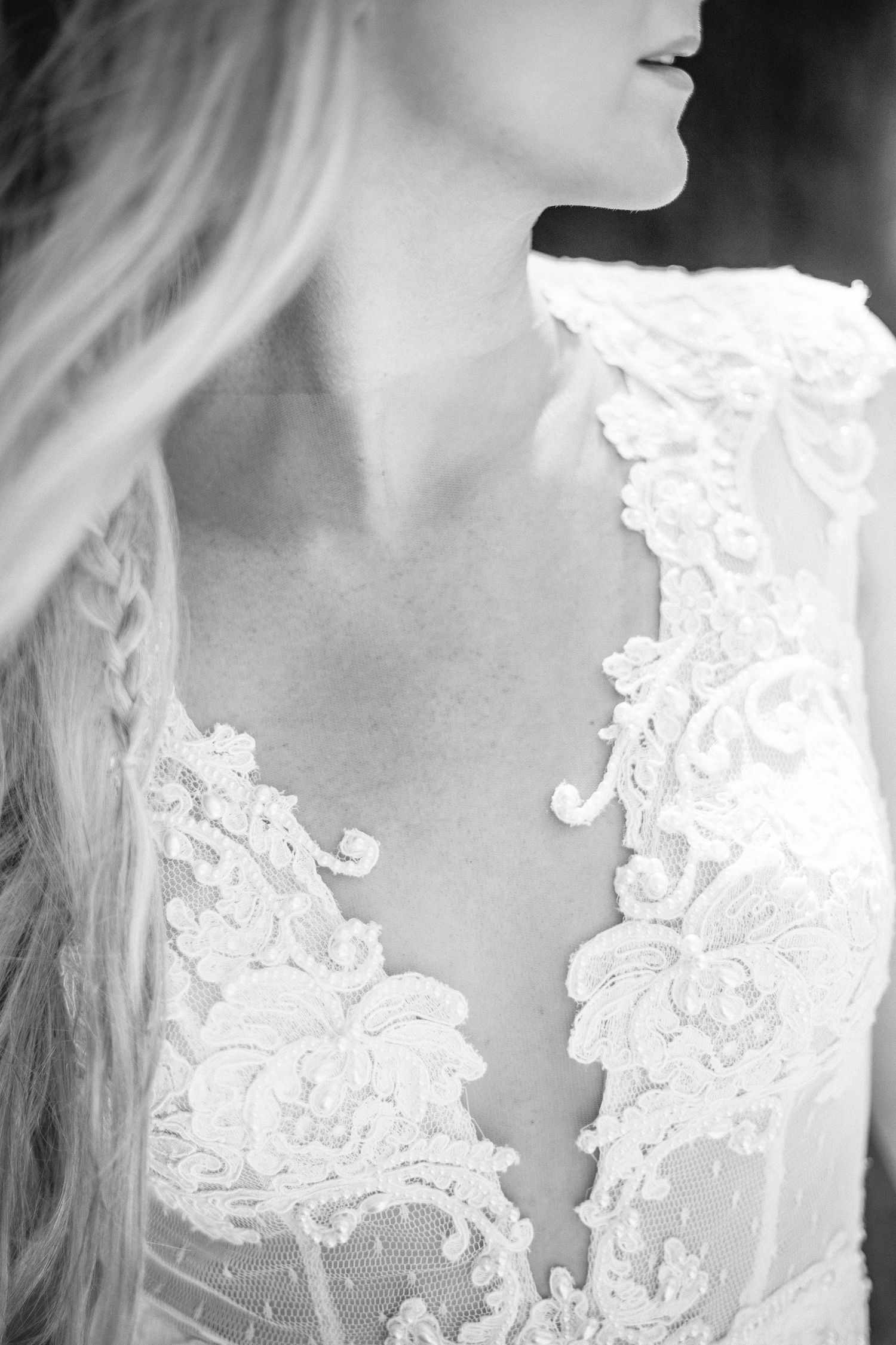 Artistic black and white close-up of intricate lace wedding dress details of berta gown.