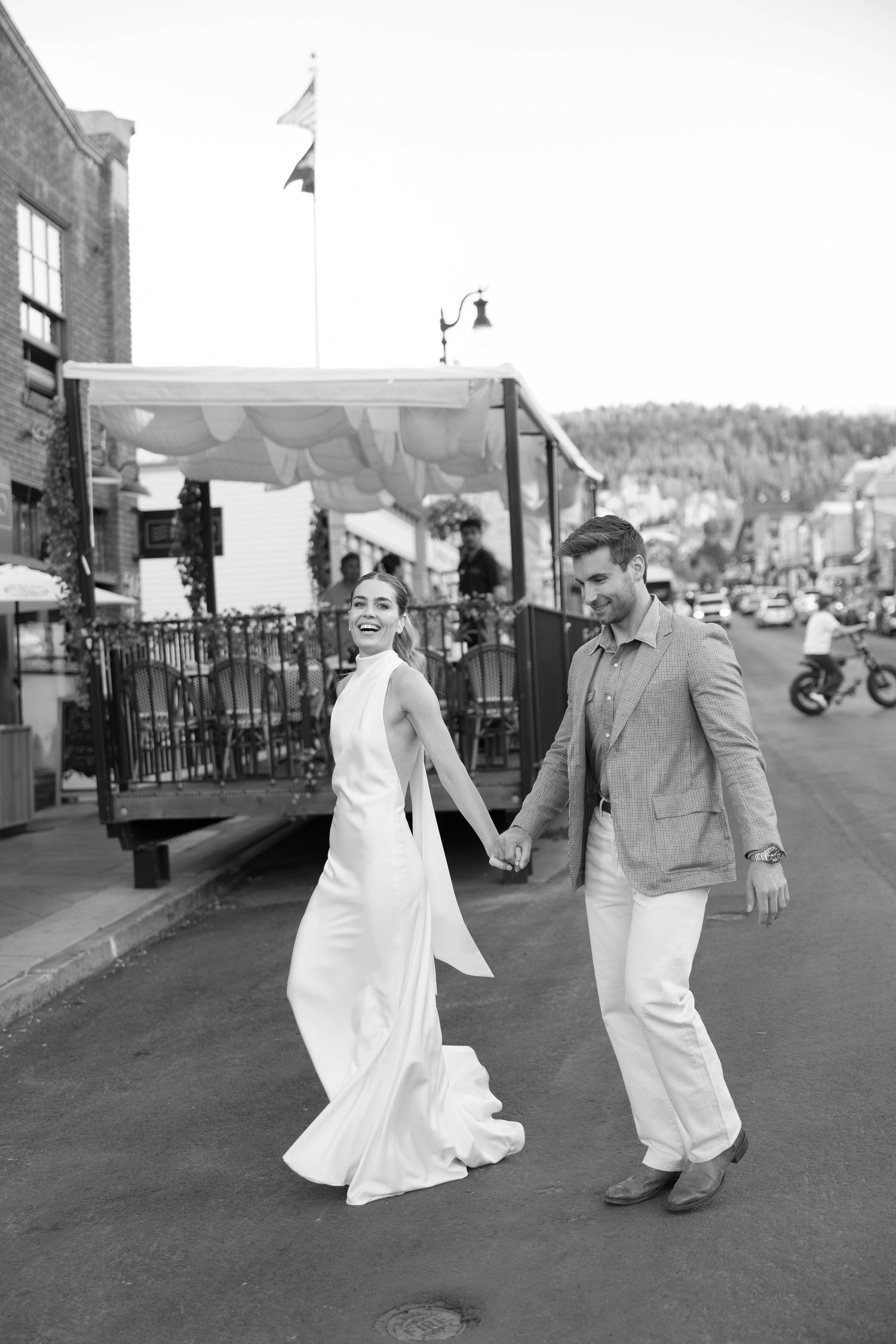 Black and white photo sequence of a couple dancing playfully on a small town street.