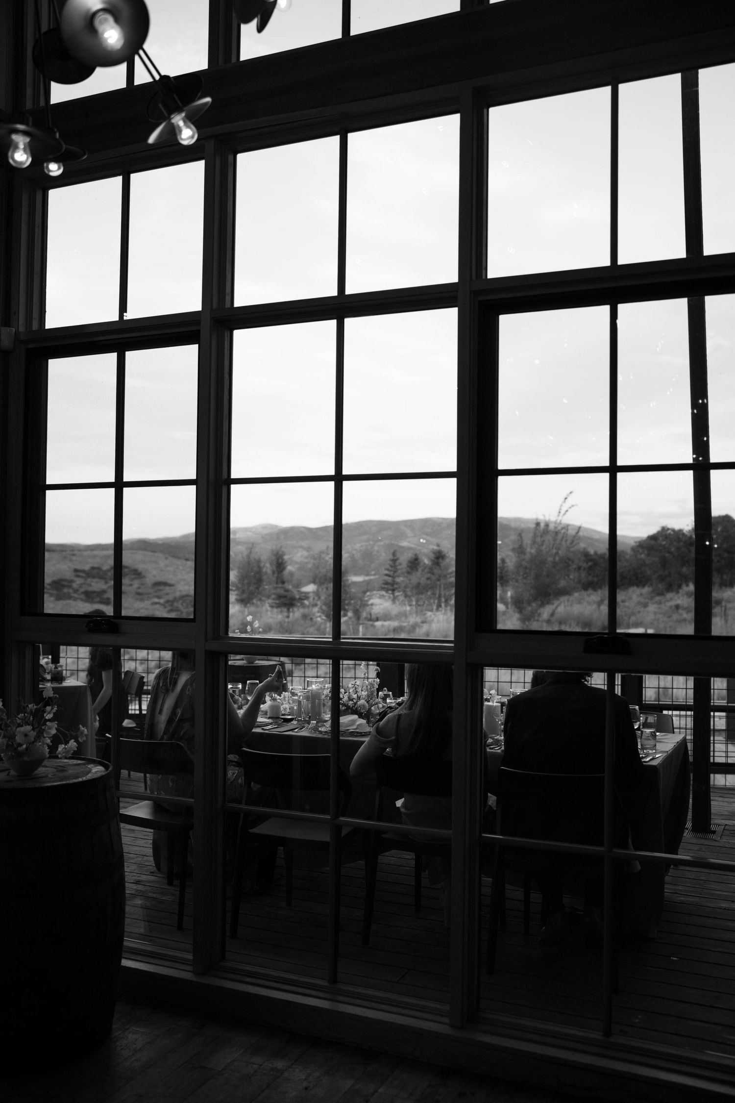 Silhouette of a modern interior space with large windows overlooking a scenic landscape.